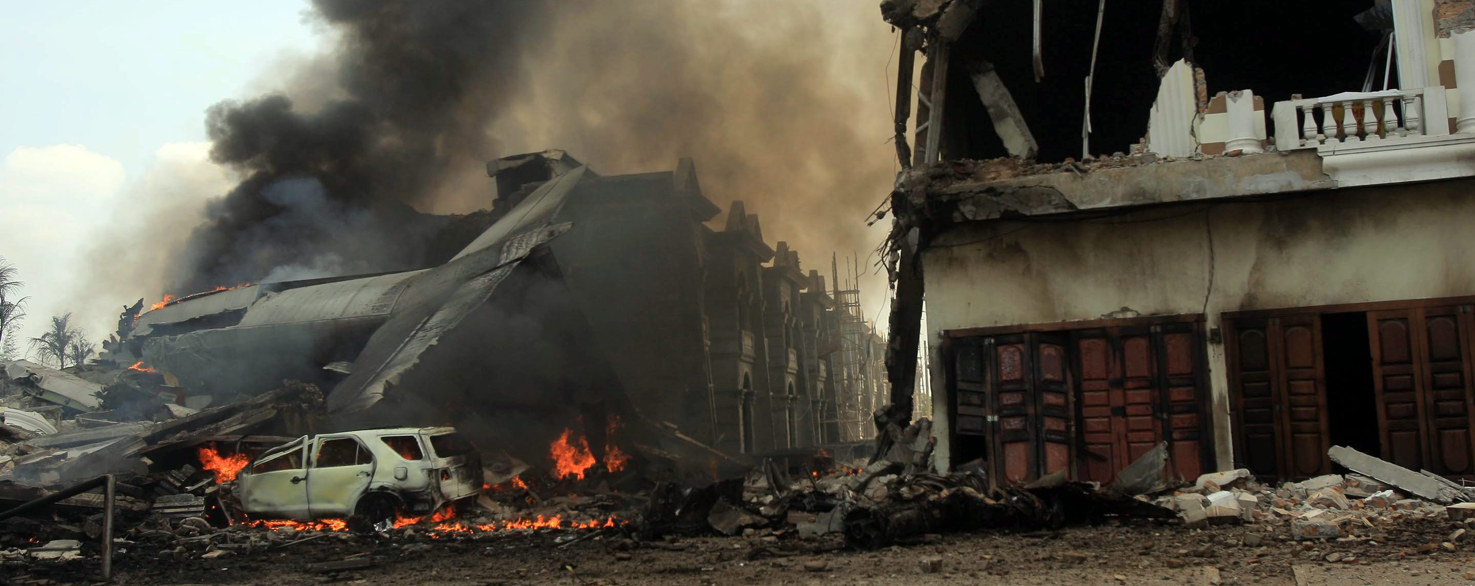 epa04824557 A crashed military airplane is on fire in Medan, North Sumatra, Indonesia, 30 June 2015. An Indonesian military C-130 aircraft crashed into a residential area and burst into flames moments after take-off in North Sumatra province, the military said. The Hercules C-130 plane was carrying 12 crew members and an unknown number of passengers. At least five crew members were killed in the accident in the city of Medan, armed forces spokesman Fuad Basya said.  EPA/DEDI SAHPUTRA