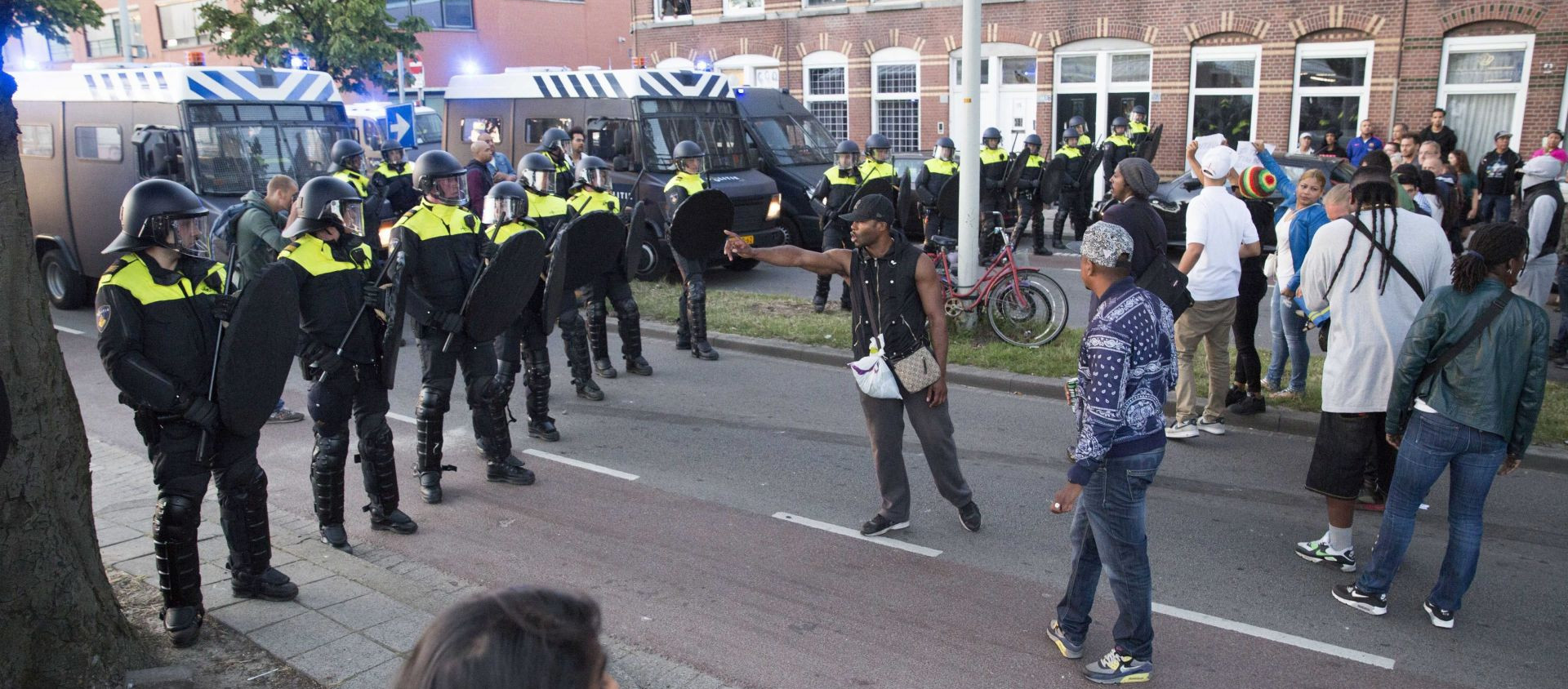 epa04824616 Police officers block a street against protesters during a riot in the Schilderswijk district of The Hague, The Netherlands, 29 June 2015. Protesters have gathered after the death of Mitch Henriquez, a 42 year old Aruban man who died on 28 June in hospital after being arrested at a music festival in the city on 27 June.  EPA/ARIE KIEVIT