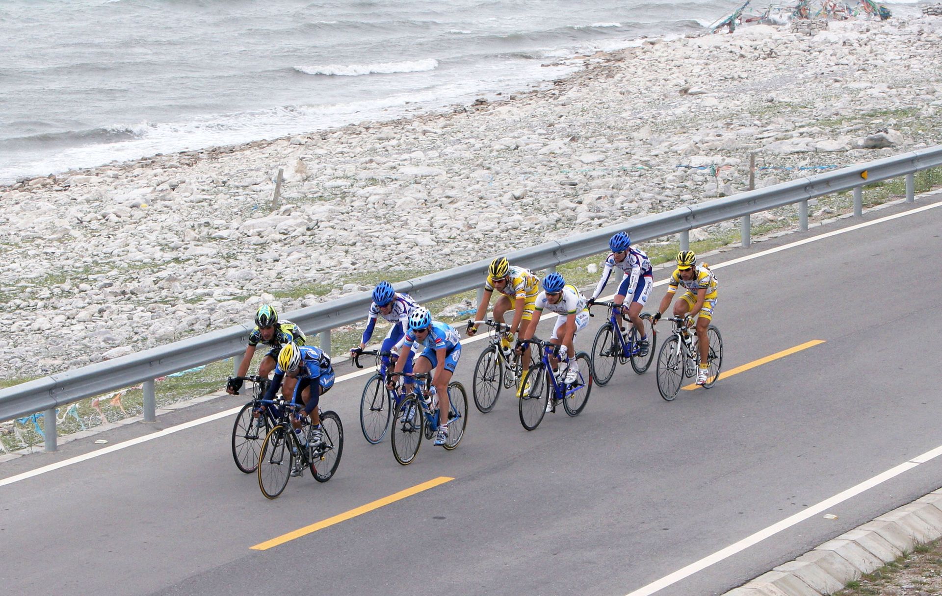 QINGHAI LAKE, CHINA - JULY 18: (CHINA OUT) Cyclists ride during the third stage of the 4th Tour de Qinghai Lake International Cycling Race along Qinghai Lake on July 18, 2005 in Qinghai Province, northwest China. The 4th Tour de Qinghai Lake will last from July 16 - 24, covering 9 stages. Twenty teams from five continents attend this year's race. Tour de Qinghai Lake is held annually since 2002. In 2004, it rose to the top road cycling race in Asia. (Photo by China Photos/Getty Images)