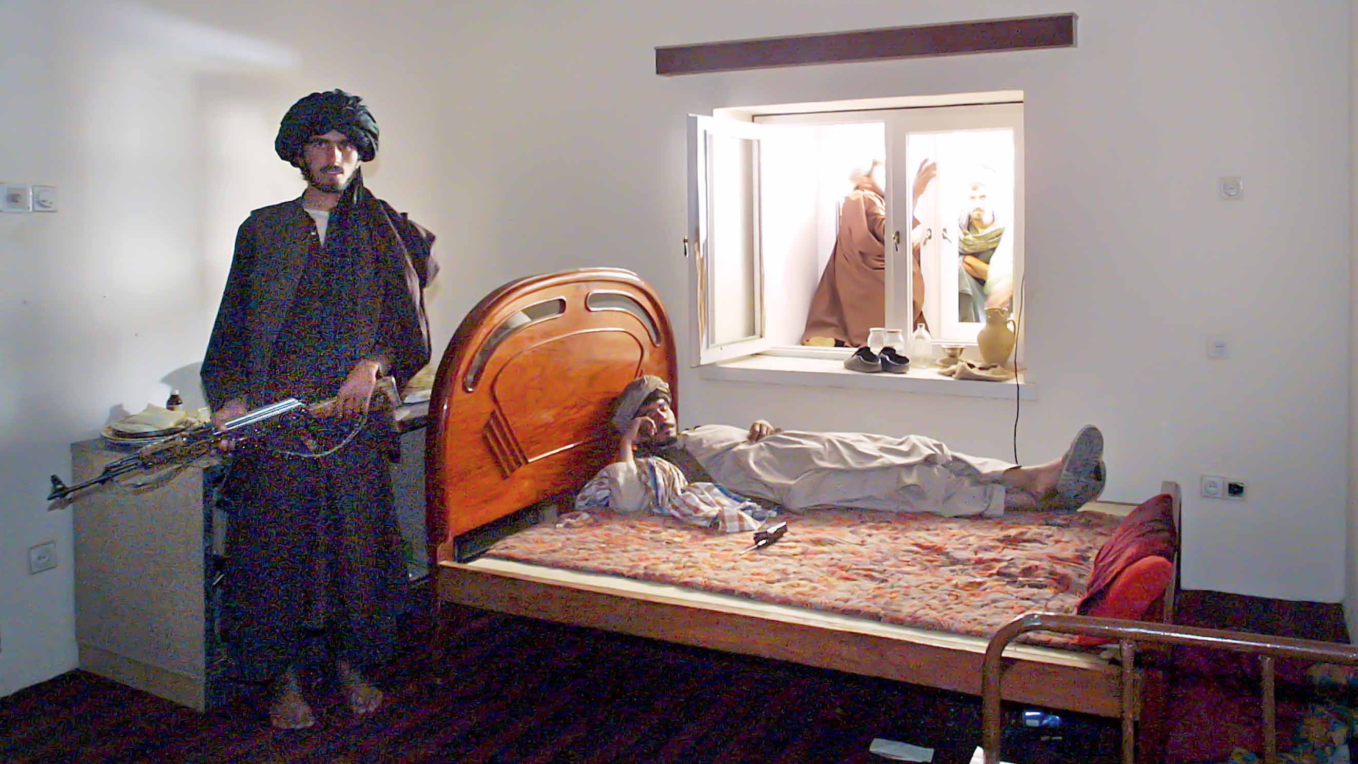 398598 01: An armed guard rests in the former bedroom of Taliban spiritual leader Mullah Mohammed Omar December 13, 2001 in Kandahar, Afghanistan. Omar evacuated his home minutes before it was bombed. His whereabouts are unknown at the moment. (Photo by Paula Bronstein/Getty Images)