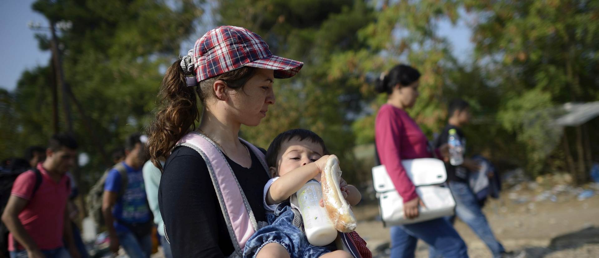 epa04898691 Migrants cross the border between the Former Yugoslav Republic of Macedonia and Greece near the town of Gevgelija, 26 August 2015. The Gevgelija-Presevo journey is just a part of the journey that the refugees, the vast majority of them from Syria, are forced to make along the so-called Balkan corridor, which takes them from Turkey, across Greece, Macedonia and Serbia to Hungary, the gateway to the European Union.  EPA/VASSIL DONEV
