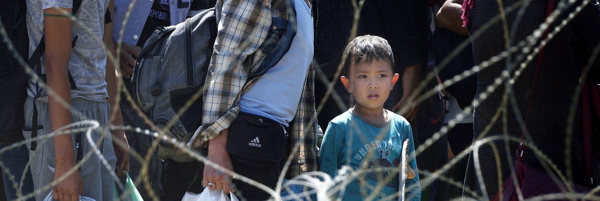 epa04901787 A migrant child waiting to cross the border, between the Former Yugoslav Republic of Macedonia and Greece, near the town of Gevgelija, 28 August 2015. The Gevgelija-Presevo journey is just a part of the journey that the refugees, the vast majority of them from Syria, are forced to make along the so-called Balkan corridor, which takes them from Turkey, across Greece, Macedonia and Serbia to Hungary, the gateway to the European Union.  EPA/VASSIL DONEV
