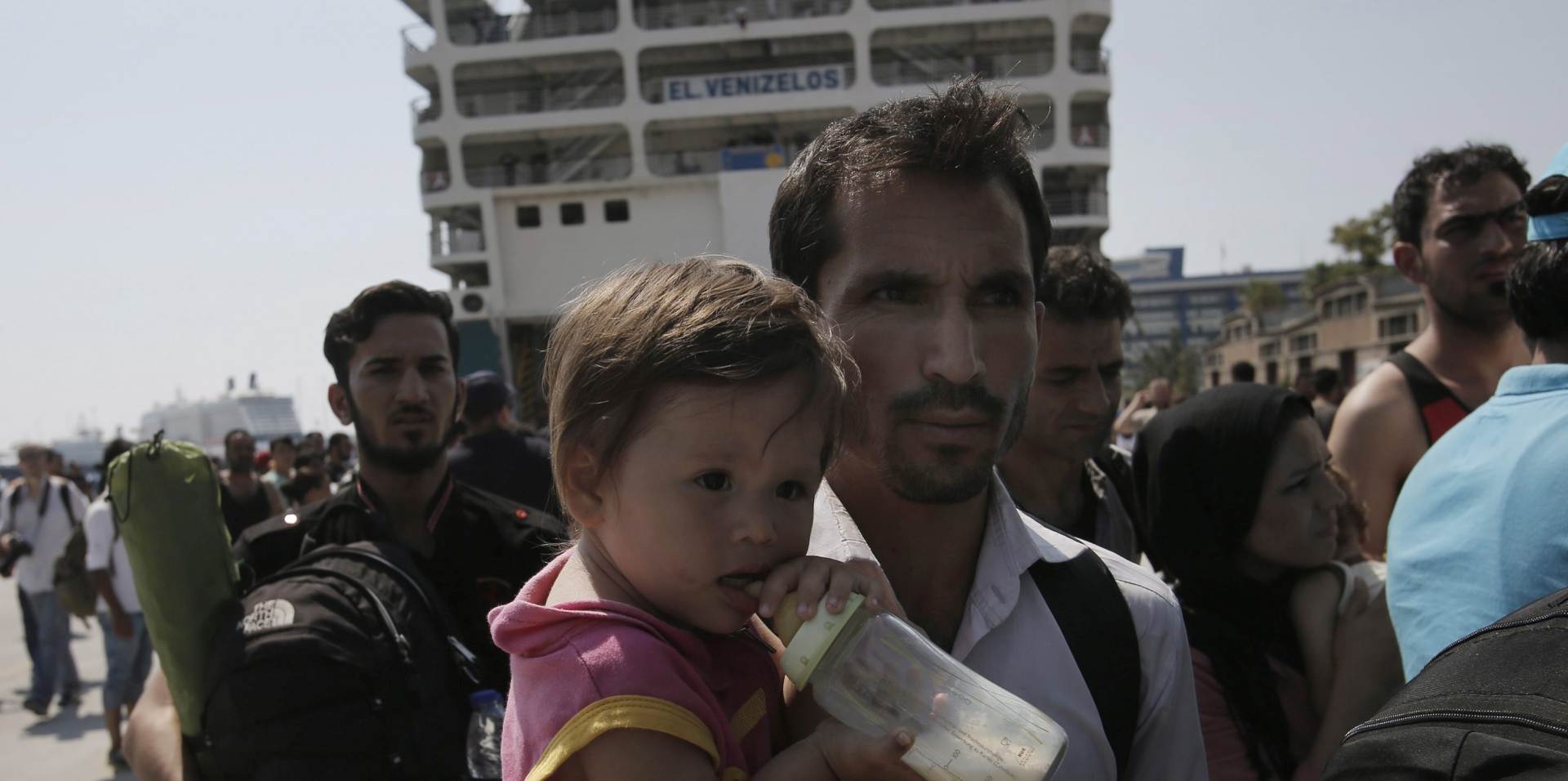 epa04914633 Refugees, mosty from Syria, wait for a bus after disembarking from the ferry 'Eleftherios Venizelos' at the port of Piraeus, near Athens, Greece, 05 September 2015. The ships 'Eleftherios Venizelos' and 'Diagoras' arrived in the port of Piareus carrying about 2,500 refugees, mostly Syrians, who landed on the Greek islands of Lesvos and Kos from Turkey. Some 20,000 refugees arrived on Greek islands last week.  EPA/YANNIS KOLESIDIS