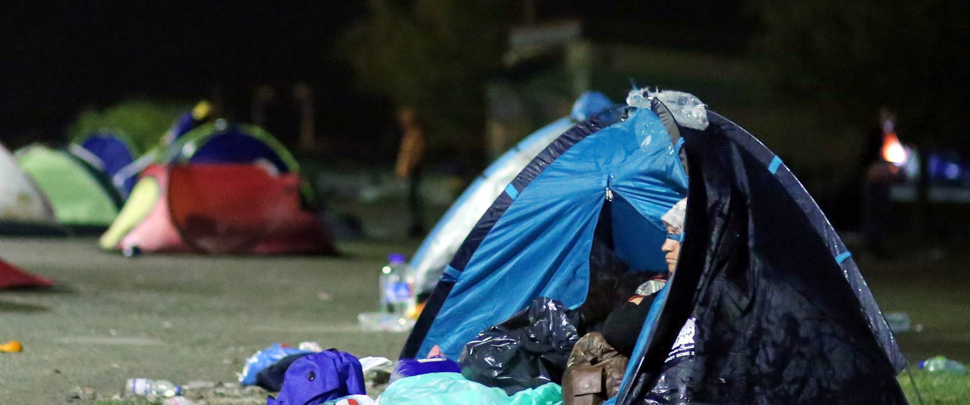 Tovarnik, 20.09.2015 - Uz kiu, vjetar i zahlaðenje, izbjeglice su noæ provele na otvorenom u kinim kabanicama i u atorima.
foto HINA/ Damir SENÈAR /ds