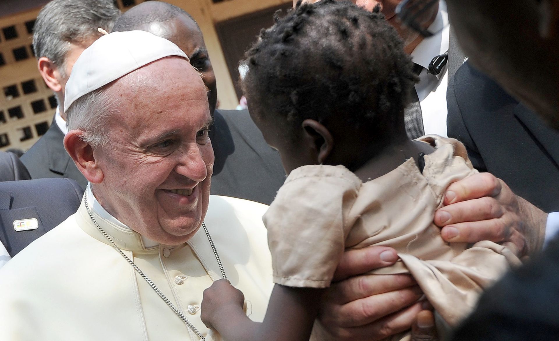 epa05047017 Pope Francis smiles at a child being held up during a visit to a refugee camp in Bangui, Central African Republic, 29 November 2015. Pope Francis is on the last leg of a six days visit that took him to Kenya, Uganda and the Repulic of Central Africa from 25 to 30 November.  EPA/DANIEL DAL ZENNARO