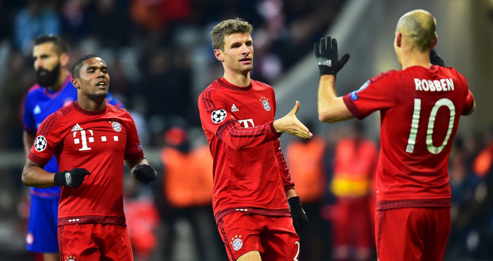 epa05040332 Bayern Munich's Thomas Mueller (C) celebrates with his teammates Douglas Costa (L) and Arjen Robben after scoring the 3-0 lead during the UEFA Champions League Group F soccer match between Bayern Munich and Olympiacos Piraeus in Munich, Germany, 24 November 2015.  EPA/PETER KNEFFEL