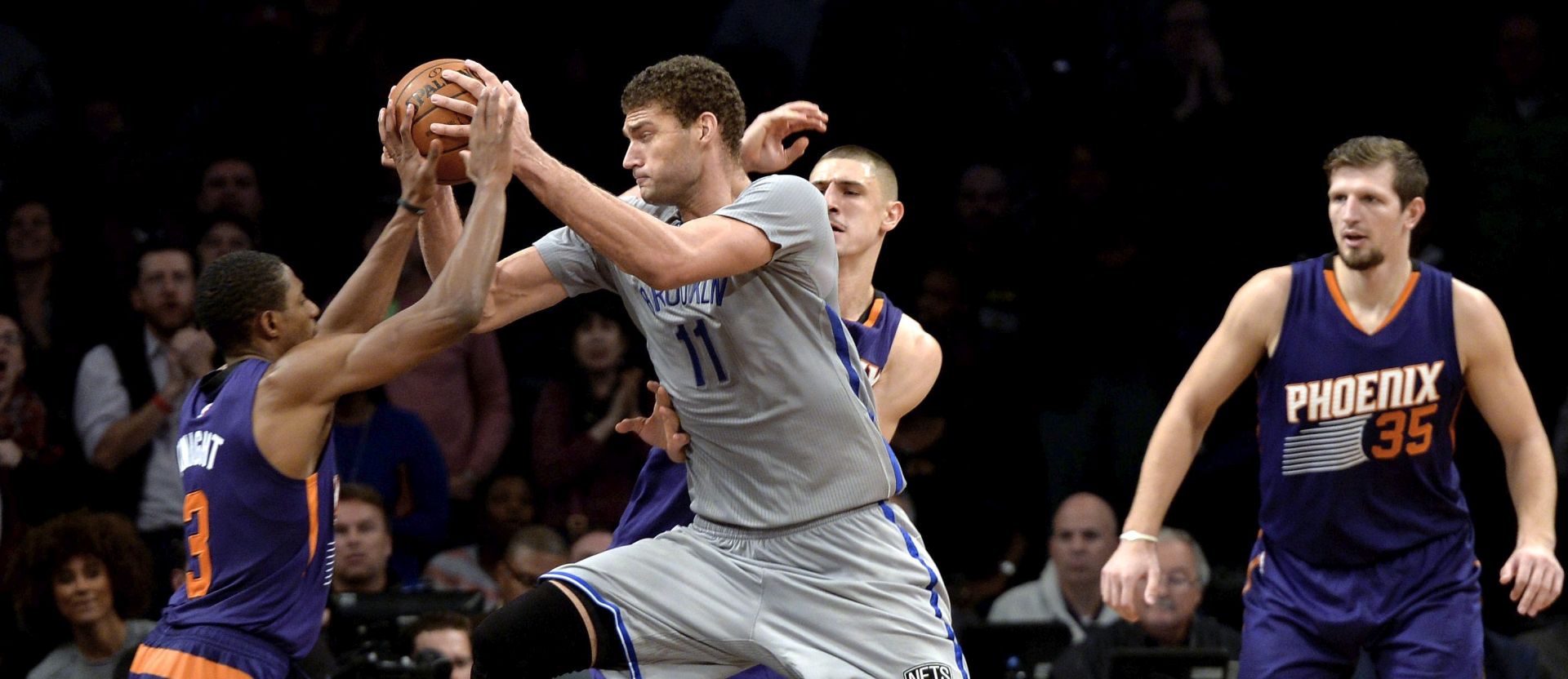 epa05051219 The Nets' Brook Lopez (C) tries to drive to the basket past the Suns' Brandon Knight (L) and Mirza Teletovic of Bosnia and Herzegovina (R) during the second half of the NBA game between the Phoenix suns and the Brooklyn Nets at the Barclays Center in Brooklyn, New York, USA, 01 December 2015. The Nets won, 94-91.  EPA/JUSTIN LANE CORBIS OUT
