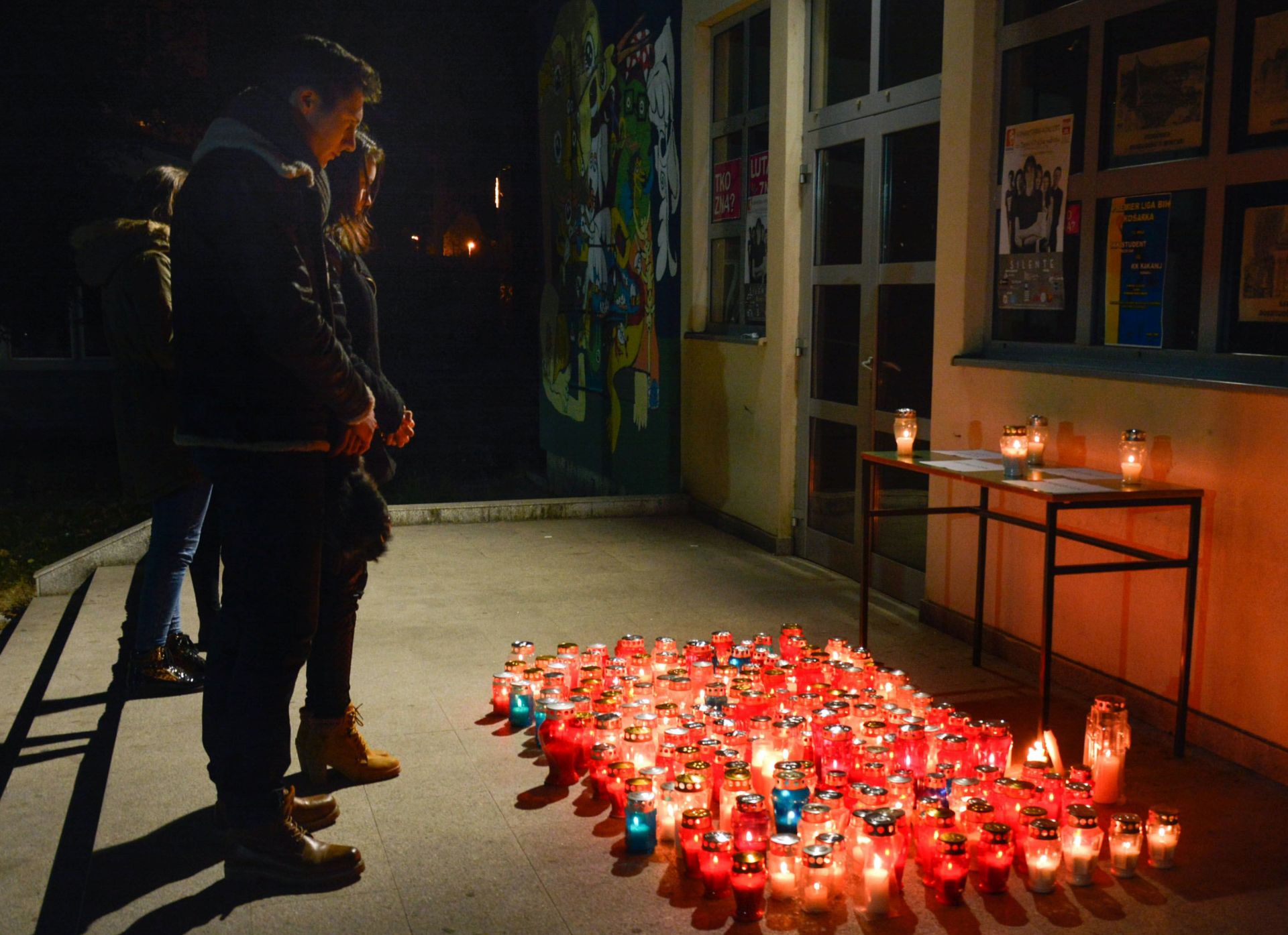 Mostar, 21.12.2015. - Tijela Domagoja Rose (25), Tene Vraèeviæ (25), Antonije ariæ (22) i Vjekoslava Boanoviæa (24), èetvero mladih ljudi koji su se u subotu utopili u Neretevi sjeverno od Mostara, u ponedjeljak su ispraæena ispred gradske mrtvaènice u Mostaru prema Vinkovcima gdje æe biti pokopana, a prije toga odrana je komemoracija na Sveuèilitu u Mostaru gdje su studirali. Na fotografiji studenti odaju poèast poginulim kolegama. 
foto HINA / Ivan ROZIÆ / FENA / mm