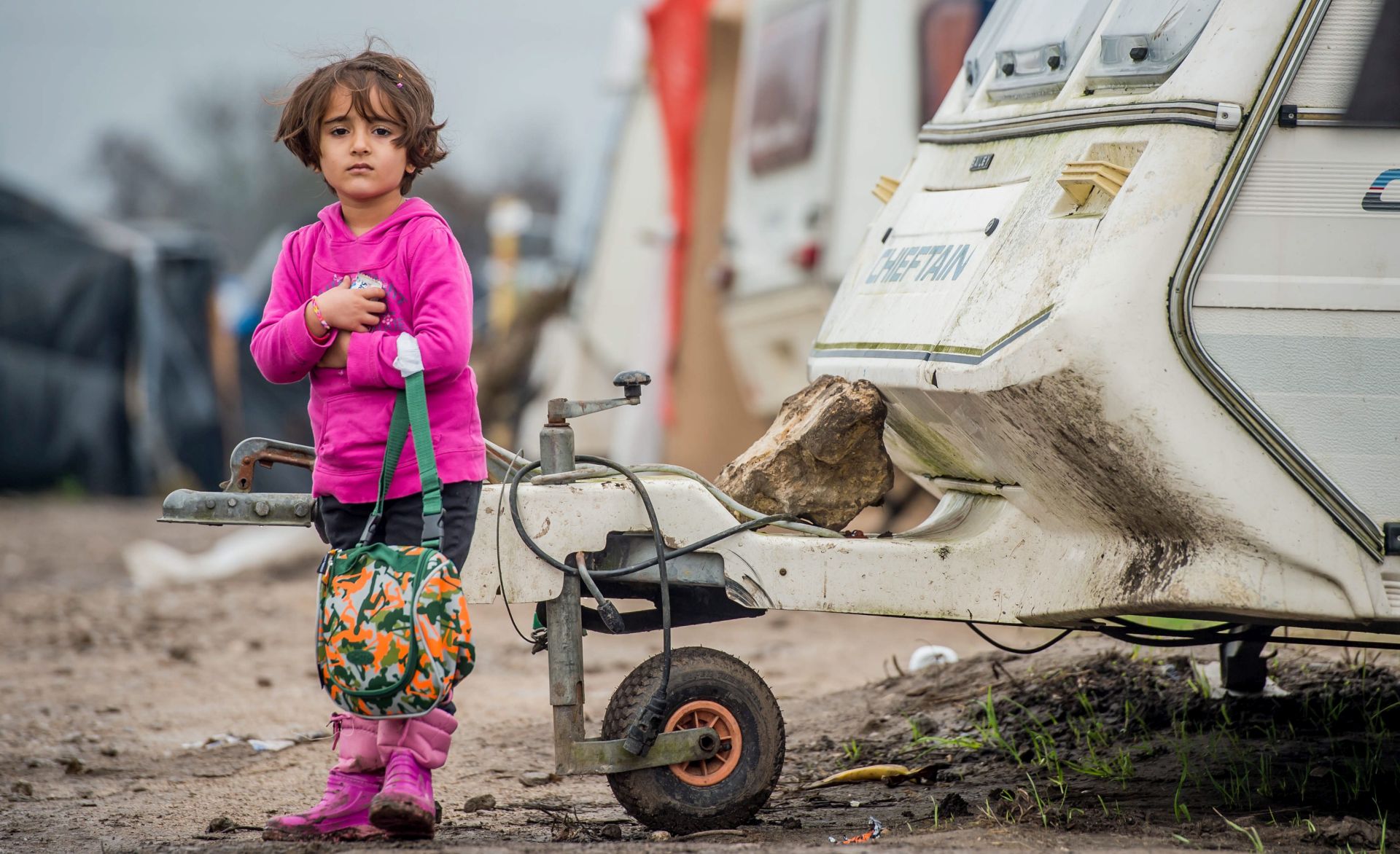 epa05080900 A refugee girl carries a small bag she received as a gift for Christmas in the refugee camp during Christmas Day in the camp called 'The Jungle' in the port of Calais, France, 25 December 2015.  Part of Calais migrant camp are Christians and celebrate Christmas. Currently the camp in Calais is housing around 1500 migrants who are looking to cross the English Channel to Britain. Among the migrants of the 'Jungle' are refugees and asylum seekers from Afghanistan, Darfur, Syria, Iraq and Eritrea.  EPA/STEPHANIE LECOCQ