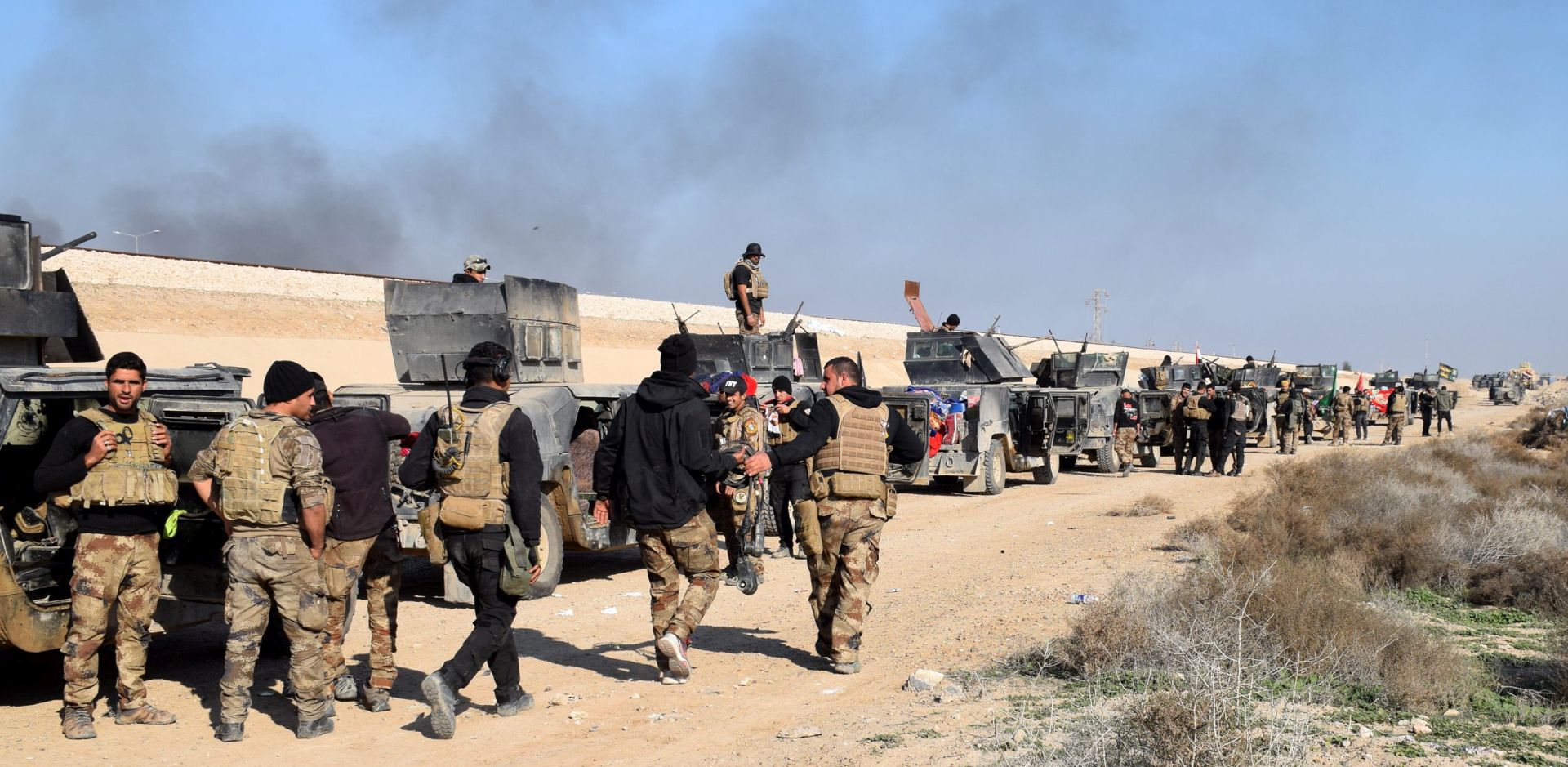 epa05079026 Iraqi military vehicles and troops advance towards the centre of Ramadi city, west of Iraq on 22 December 2015. The Iraqi military forces launched a military operation to retake the provincial capital from IS amid reports IS was preventing civilians from leaving the city. Despite being backed by airstrikes from a US led coalition and estimates between 250 to 300 IS fighters remained in the city.  EPA/STR