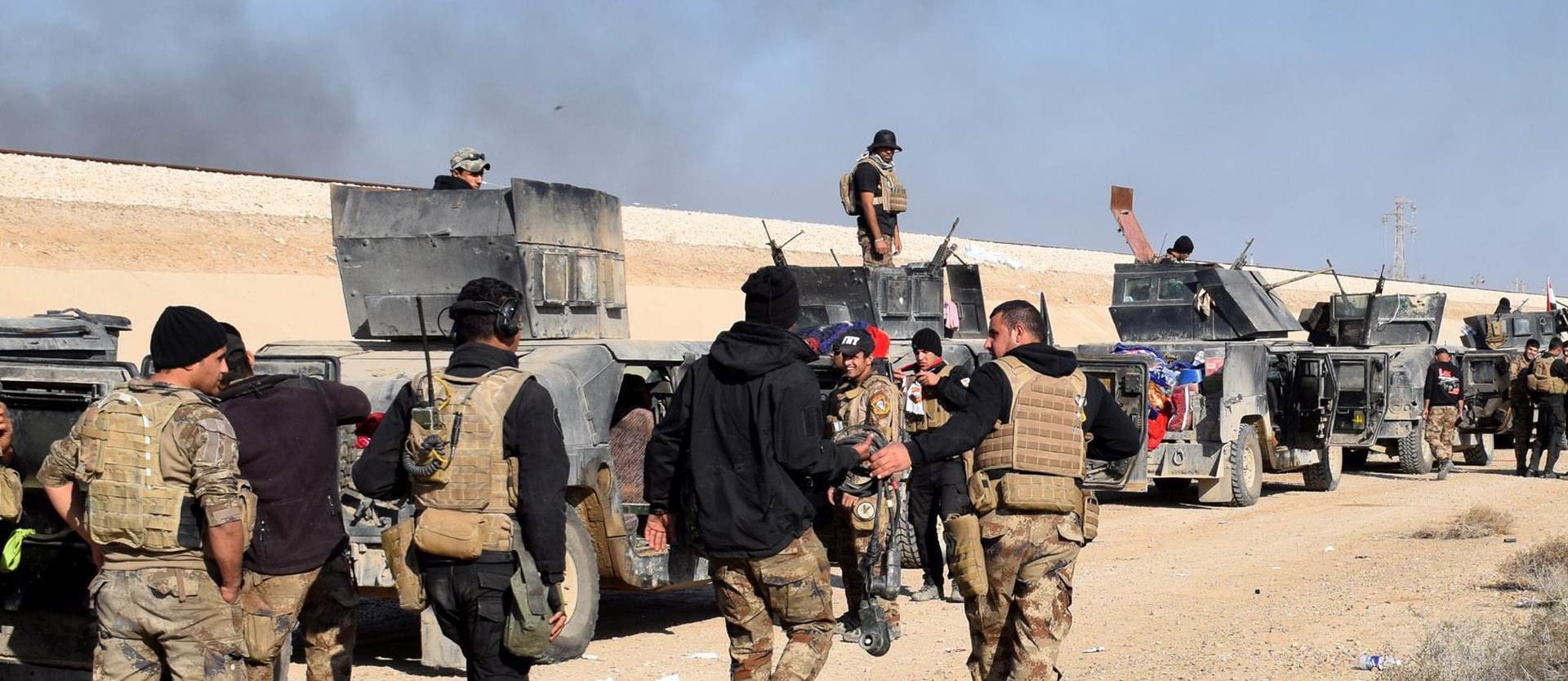 epa05079026 Iraqi military vehicles and troops advance towards the centre of Ramadi city, west of Iraq on 22 December 2015. The Iraqi military forces launched a military operation to retake the provincial capital from IS amid reports IS was preventing civilians from leaving the city. Despite being backed by airstrikes from a US led coalition and estimates between 250 to 300 IS fighters remained in the city.  EPA/STR