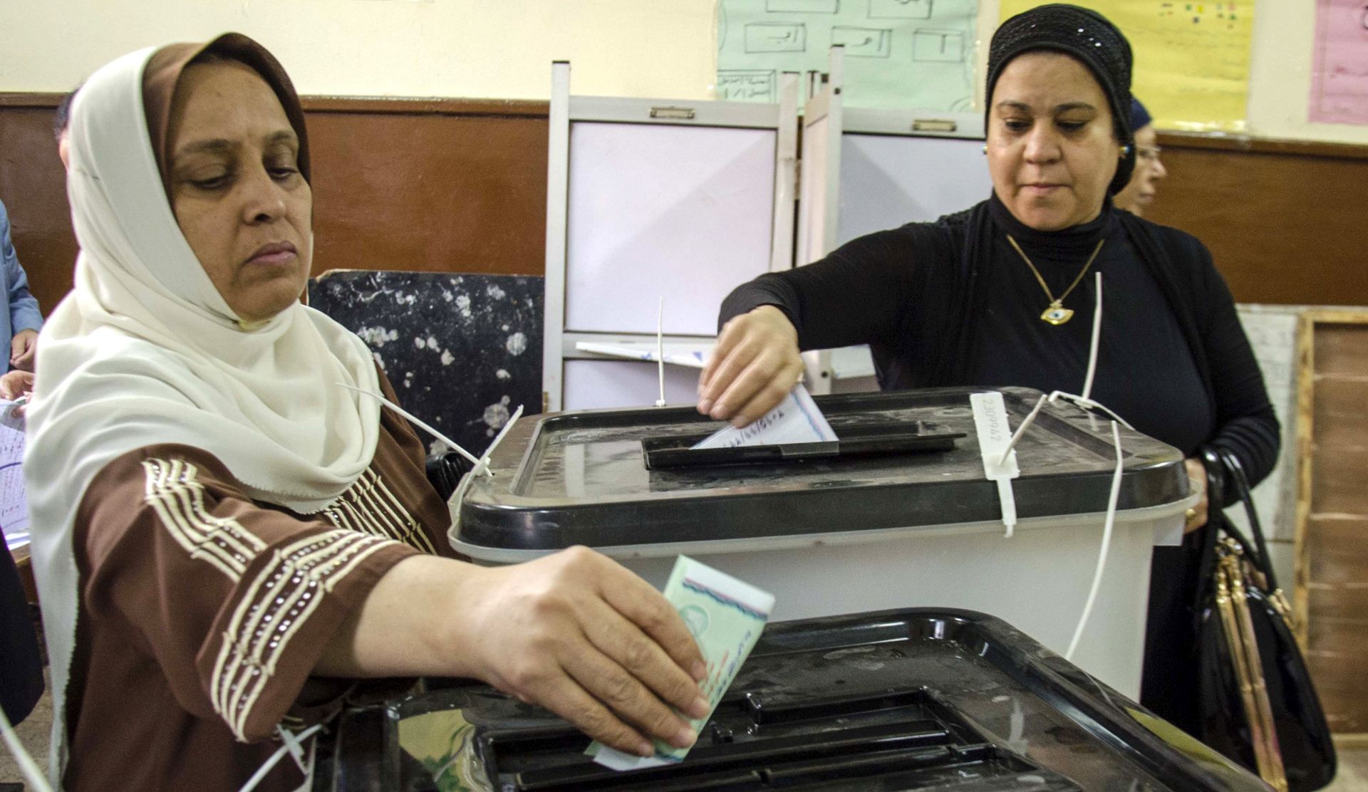 epa05038358 Egyptian women cast their ballot papers during the second day of voting in the second and final round of the parliamentary elections, at a polling station in Cairo, Egypt, 23 November 2015. Few Egyptians were showing up on 23 November to vote in the final day of parliamentary elections that are expected to be led by backers of President Abdel-Fattah al-Sisi.  EPA/AYMAN AREF EGYPT OUT