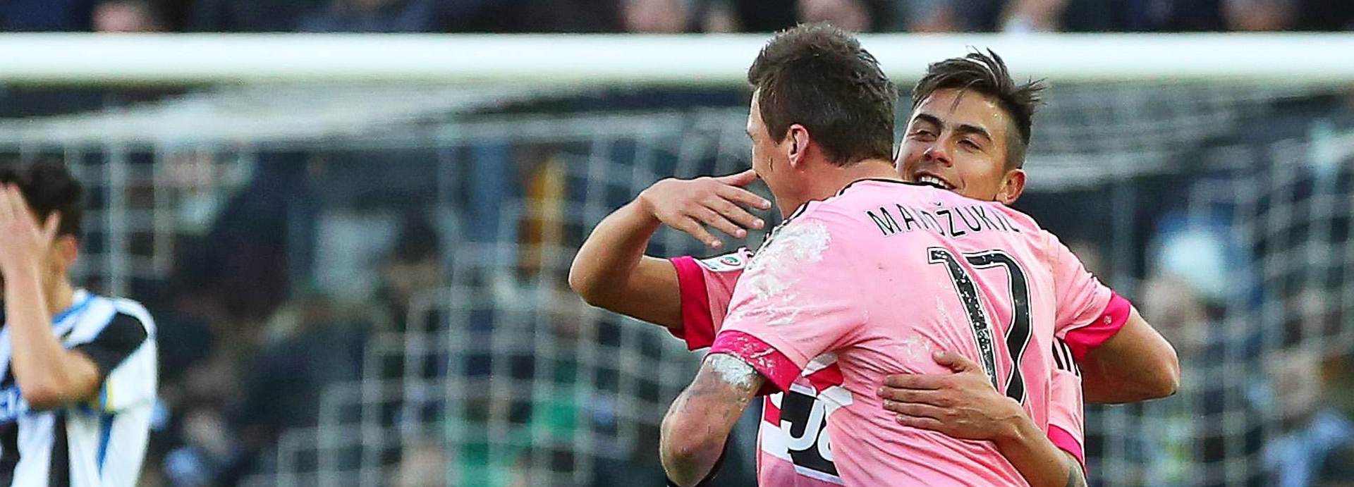 epa05106948 Juventus forward Paulo Dybala (back R) celebrates with his teammate Mario Mandzukic (front) after scoring the 3-0 lead from the penalty spot during the Italian Serie A soccer match between Udinese Calcio and Juventus FC at Friuli Stadium in Udine, Italy, 17 January 2016.  EPA/ALBERTO LANCIA