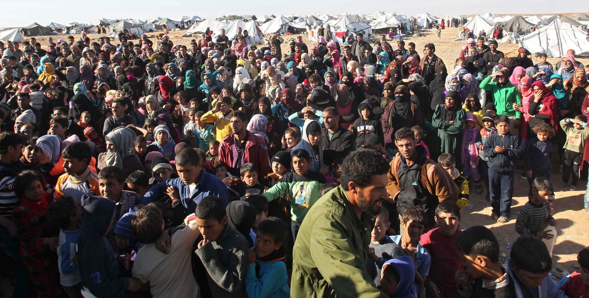 epa05102349 Syrian refugees wait at the north-eastern Jordan border with Syria, near Royashed Town, Jordan, 14 January 2016. According to the Jordanian news agency Petra, the Jordan Response Plan 2015' (JRP 2015) estimates the total number of Syrian refugees to be around 1.5 million, almost 650,000 of which are registered as refugees.  EPA/STR