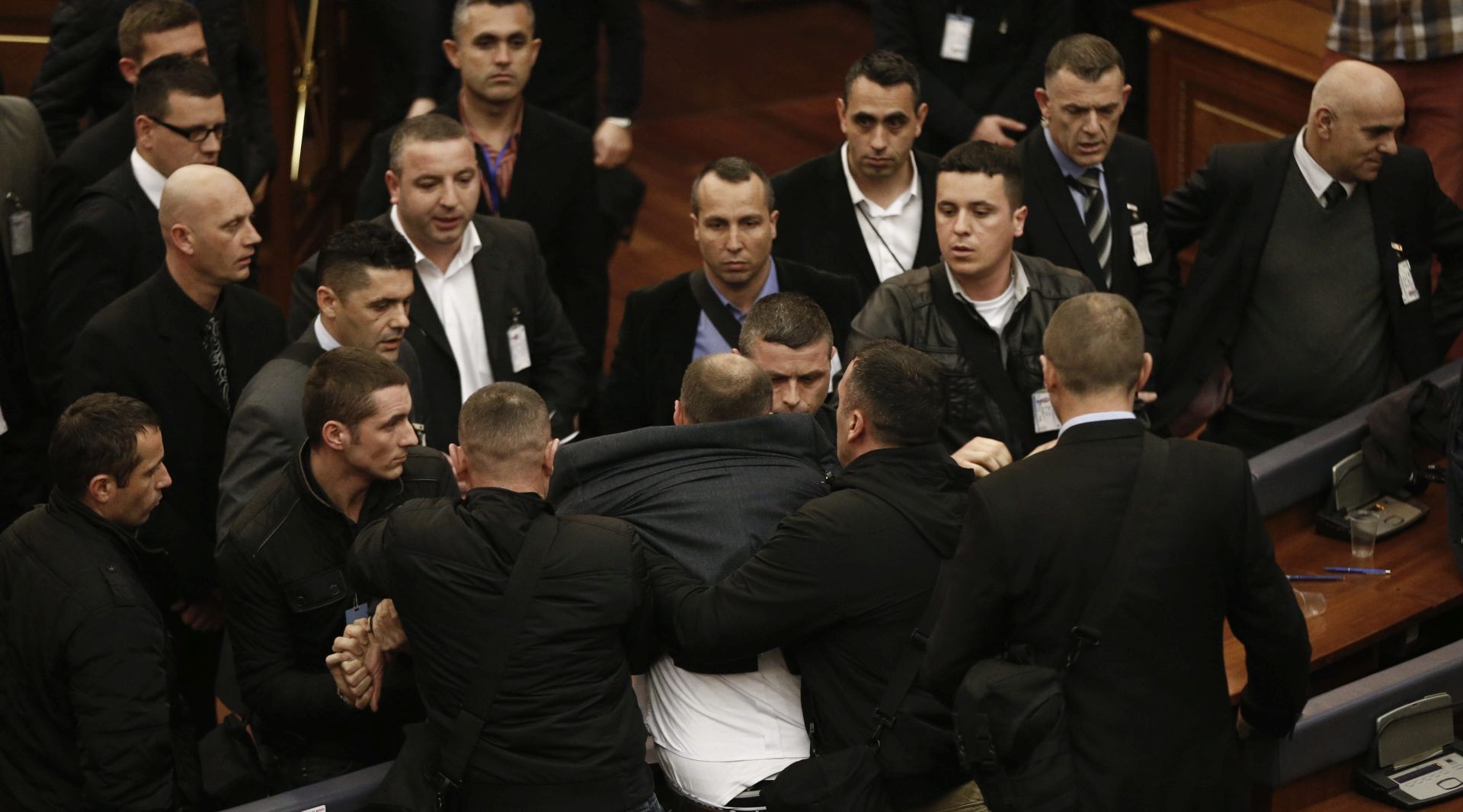 epa05182145 Kosovo police officers drag the leader of the biggest opposition party Vetevendosje (Self-determination) Visar Ymeri (C) after he was suspended from the extraordinary session to elect the new Kosovo's President as opposition lawmakers throw tear gas at the parliament in Pristina, Kosovo, 26 February 2016. The session began an hour late as several opposition lawmakers were expelled from the parliament on suspicion of carrying tear-gas canisters. The opposition, which since October has routinely disrupted the work of parliament with violence, including tear-gas attacks, vowed to fight the election. The Kosovo parliament convened to elect a new president amid heavy security and worries about violence.  EPA/VALDRIN XHEMAJ