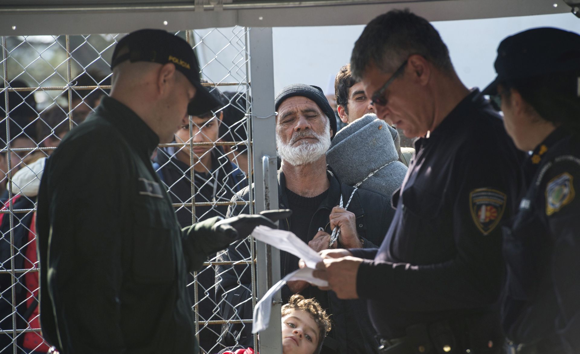 epa05169968 Macedonian police officers check the documents of refugees who want to cross the border between Greece and Macedonia near Gevegelija, The Former Yugoslav Republic of Macedonia, 19 February 2016. Checks of refugees attempting to cross the border from Greece to Macedonia were intensified. After checking the documents, every single person was undergoing a thorough check for several minutes inside a tent. Thousand refugees continue to pass through Macedonia on their way to the European Union.  EPA/GEORGI LICOVSKI