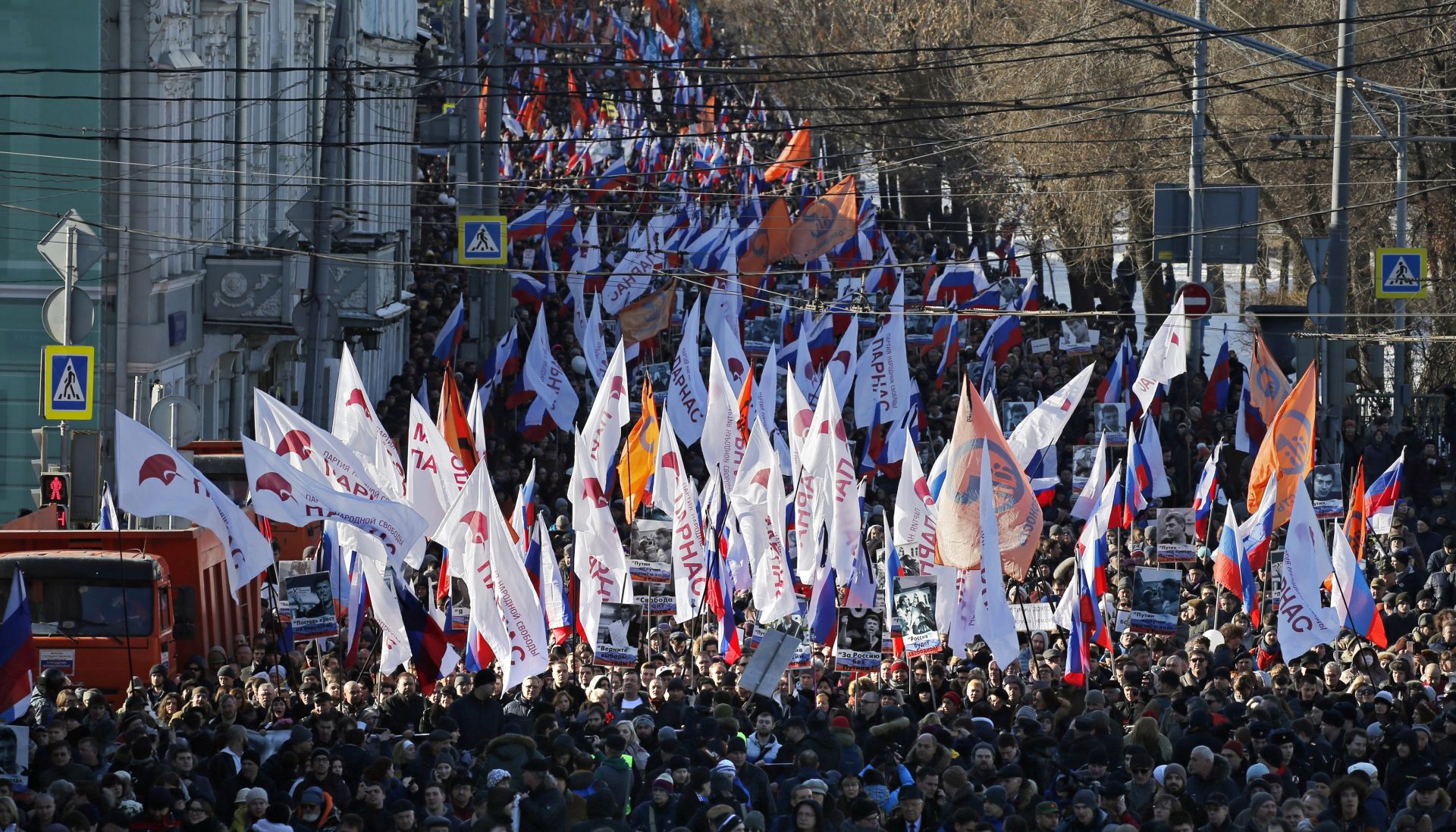 epa05183388 Russian people carry portraits during a memorial march for Boris Nemtsov to mark the murder's first anniversary, in Moscow, Russia, 27 February 2016. Boris Nemtsov, liberal opposition leader and sharp critic of president Putin, was killed on 27 February 2015 by a group of Chechen military servicemen. Five were arrested, one was killed during detention, and one of organizers is still wanted.  EPA/YURI KOCHETKOV