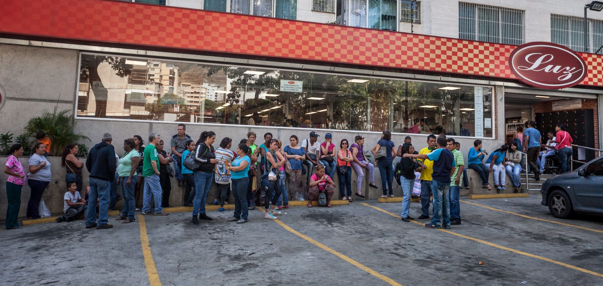 epa05105679 Dozens of people line up out of a marketplace to buy food in Caracas, Venezuela, on 16 January 2016. Venezuela, with the largest proven oil reserves of the world, declares its economy in emergency to deal with the crisis in the country where annual inflation has reached 141.5 percent.  EPA/MIGUEL GUTIERREZ