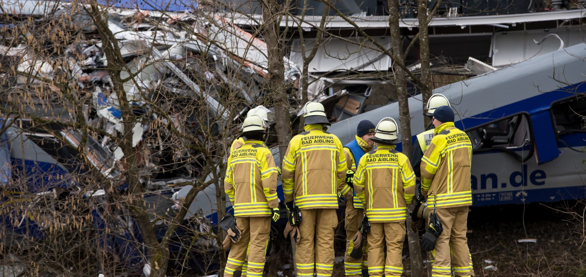 epa05152455 Firefighters stand at the site of a train crash near Bad Aibling, Germany, 10 February 2016. At least 10 people were killed and 80 injured in the accident when two commuter trains collided on 09 February 2016.  EPA/SVEN HOPPE