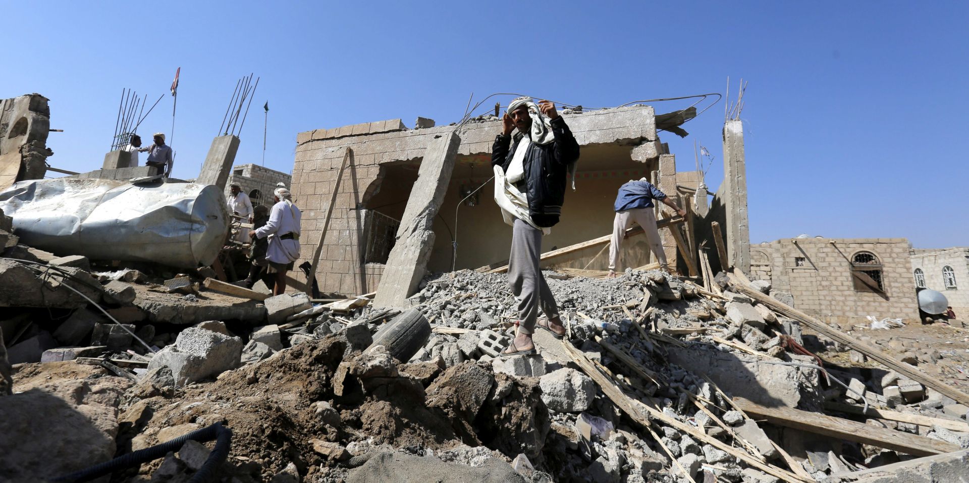 epa05138475 Yemenis stand over the rubble of houses destroyed by a Saudi-led airstrike targeting a neighborhood, in Sana'a, Yemen, 01 February 2016. According to reports, the Saudi-led coalition launched an investigation into allegations of violations in Yemen, including the death of innocent people and numerous casualties. United Nations figures show nearly 6000 people have been killed and more than 32,000 injured so far in the ten-month conflict in the war-torn Yemen since March.  EPA/YAHYA ARHAB