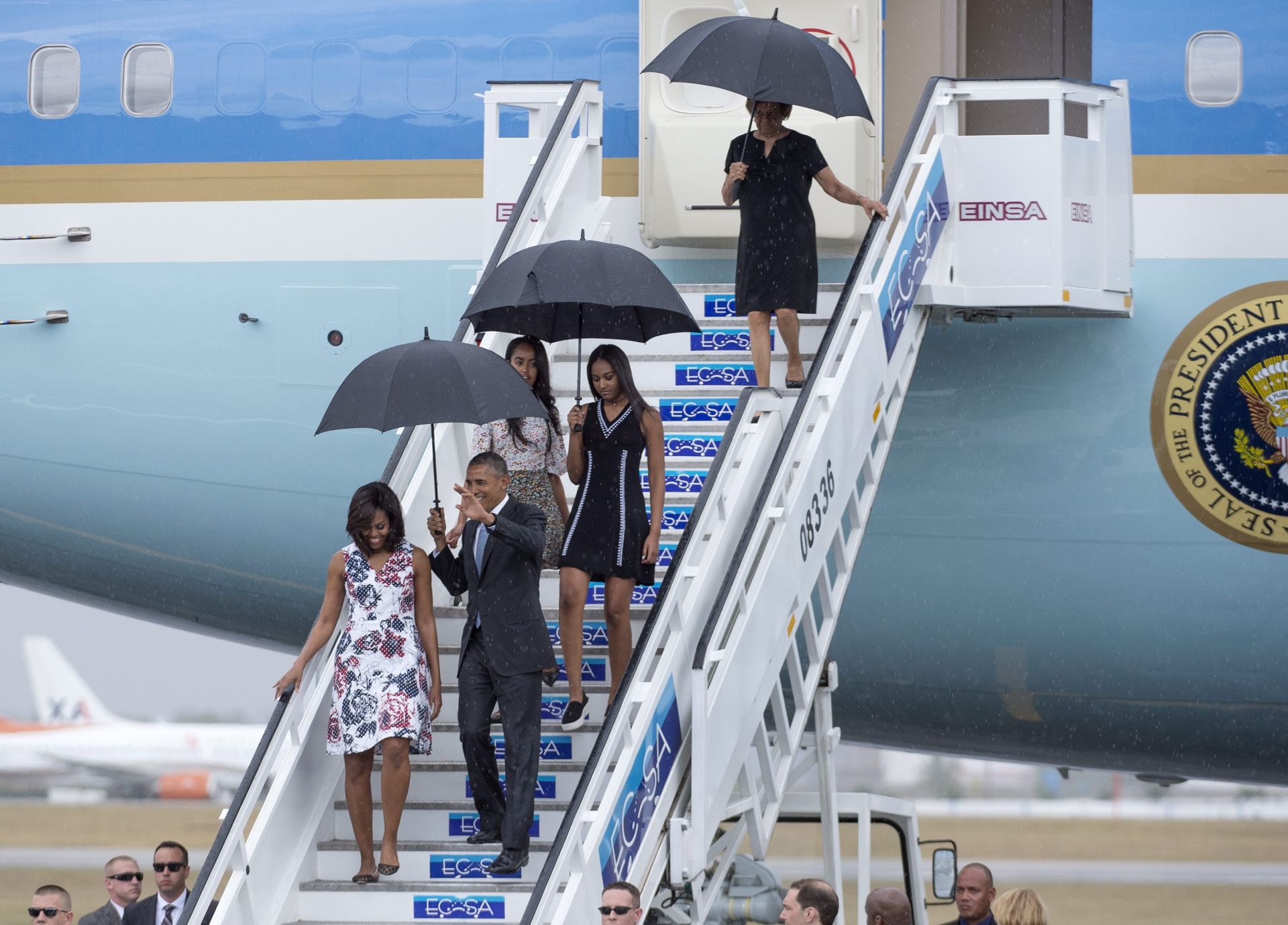 epa05223385 US President Barack Obama (R) waves beside First Lady Michelle Obama (L), their daughters Malia (back L) and Sasha (back R) and mother-in-law, Marian Shields Robinson (top) as they disembark from the 'Air Force One' plane upon arrival at the Jose Marti International Airport in Havana, Cuba, 20 March 2016. US President Barack Obama arrived for an official visit to Cuba from 20 to 22 March 2016, the first US president to visit since Calvin Coolidge 88 years ago.  EPA/MICHAEL REYNOLDS