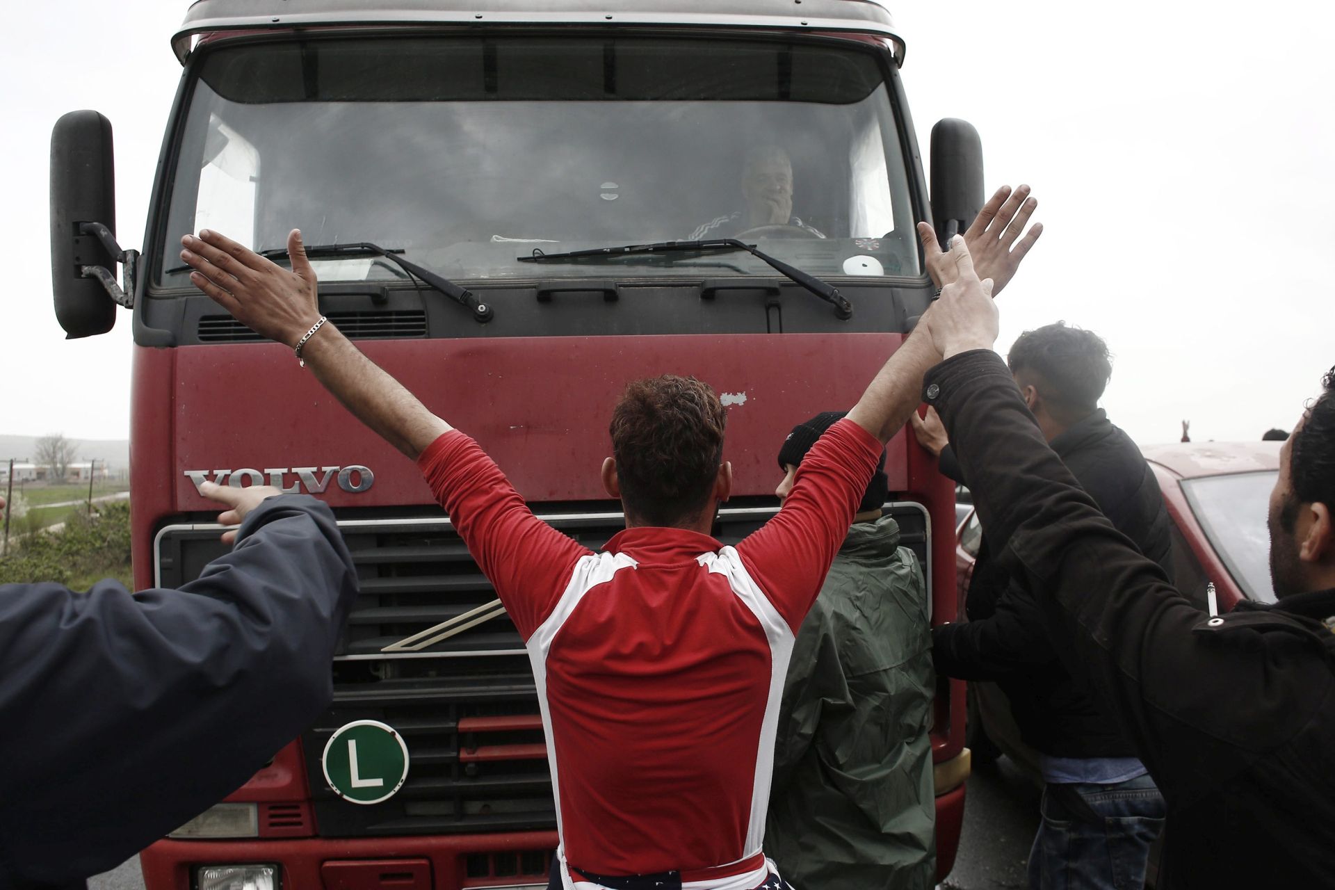 epa05227632 Refugees and migrants block a road near the refugee camp of Idomeni, demanding the the border between Greece and Macedonia be opened, Idomeni, Greece, 23 March 2016. Migration restrictions along the so-called Balkan route, the main path for migrants and refugees from the Middle East to the EU, has left thousands of migrants trapped in Greece.  EPA/KOSTAS TSIRONIS