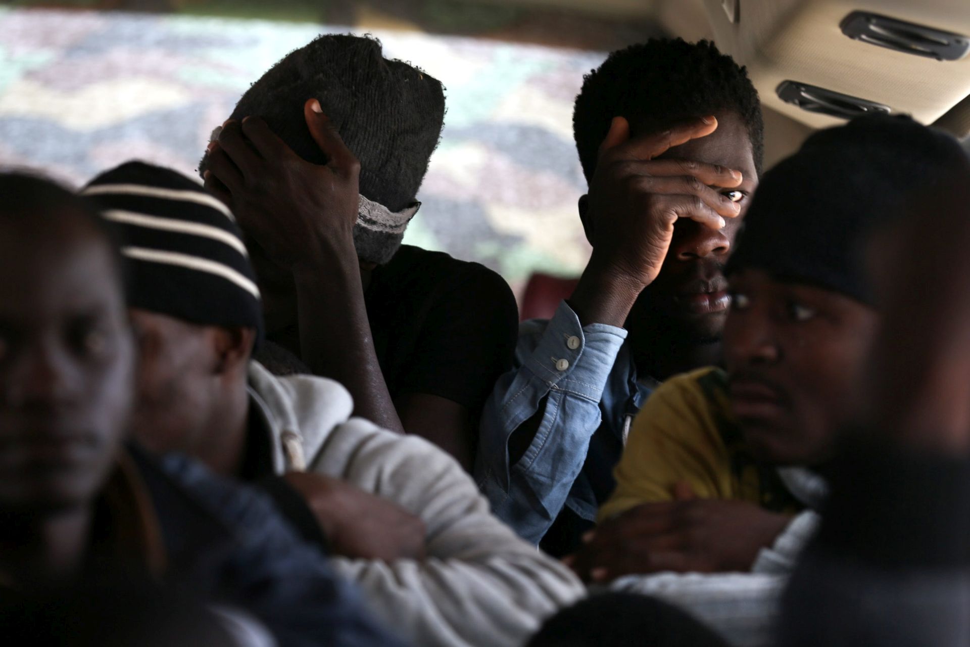 epa05254393 Migrants wait on a bus before they are transferred to a migration center, in Tripoli, Libya, 11 April 2016. Reports state Libyan costal guards rescued 115 migrants after a failed attempt to reach Europe.  EPA/STRINGER