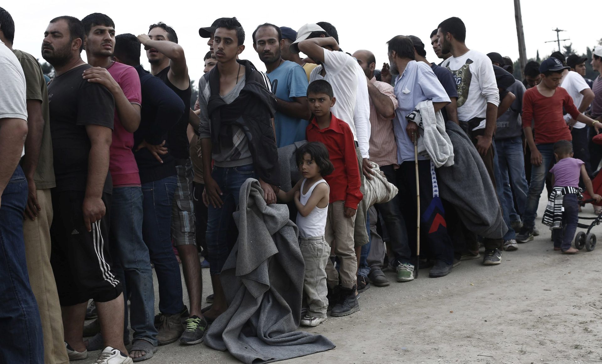 epa05267610 Refugees queue to receive firewood provided by humanitarian agencies at the makeshift refugee camp of Idomeni near the Greek-FYROM borders, 19 April 2016.  EPA/KOSTAS TSIRONIS