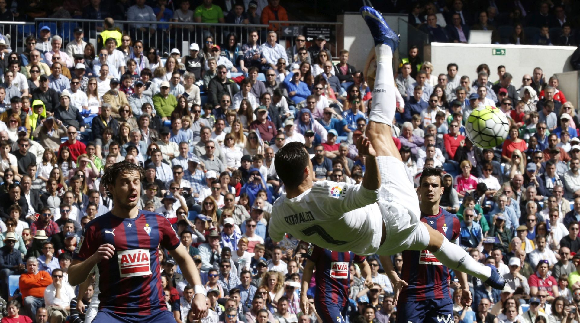 epa05251021 Real Madrid's Portuguese forward Cristiano Ronaldo (C) performs a scissors kick during their Spanish Primera Division Liga soccer match against Eibar at the Santiago Bernabeu stadium in Madrid, Spain, 09 April 2016.  EPA/Angel Diaz