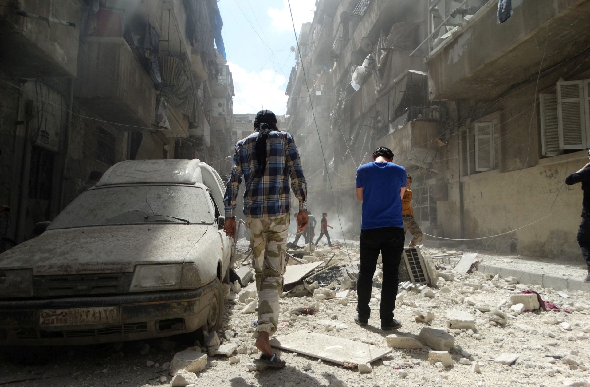 epa05281941 Syrians gather at the site of airstrikes in the rebel-held neighbourhood of Kalasa in Aleppo, Syria, 28 April 2016. At least 34 people were killed by shelling and missile fire in the Syrian city of Aleppo, the largest in the north of the country, the Syrian Observatory for Human Rights, or SOHR, reported on 28 April. Among those were at least 20 people killed by the airstrikes of warplanes, the identity of which is still unknown, in the neighborhoods of Bustan al-Qasr and al-Kalasa, according to SOHR.  EPA/ZOUHIR AL SHIMALE
