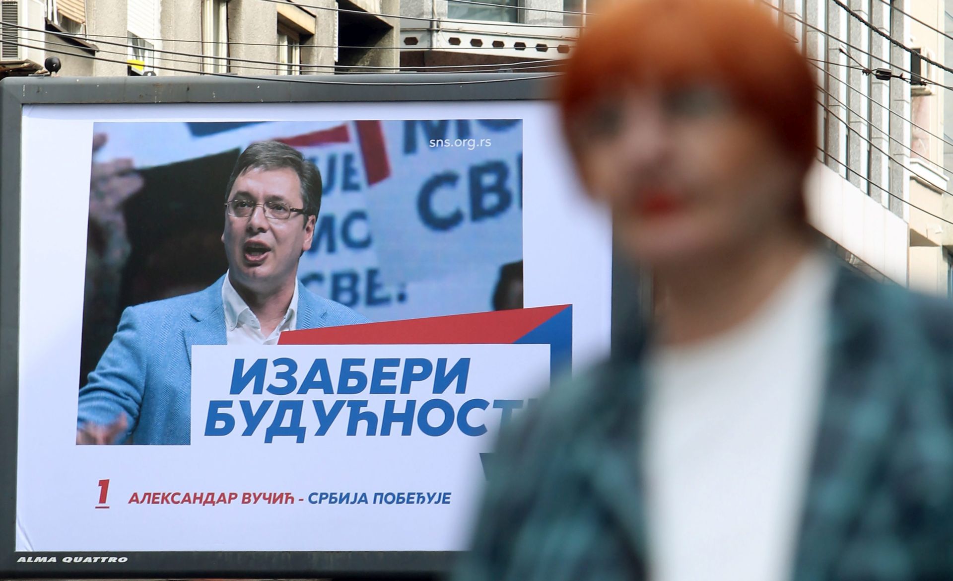 epa05273846 People walk past an election poster of poster of Prime Minister of Serbia and Serbian Progressive Party (SNS) leader Aleksandar Vucic in Belgrade, Serbia, 23 April 2016. Serbia is holding a snap parliamentary election on 24 April 2016.  EPA/KOCA SULEJMANOVIC