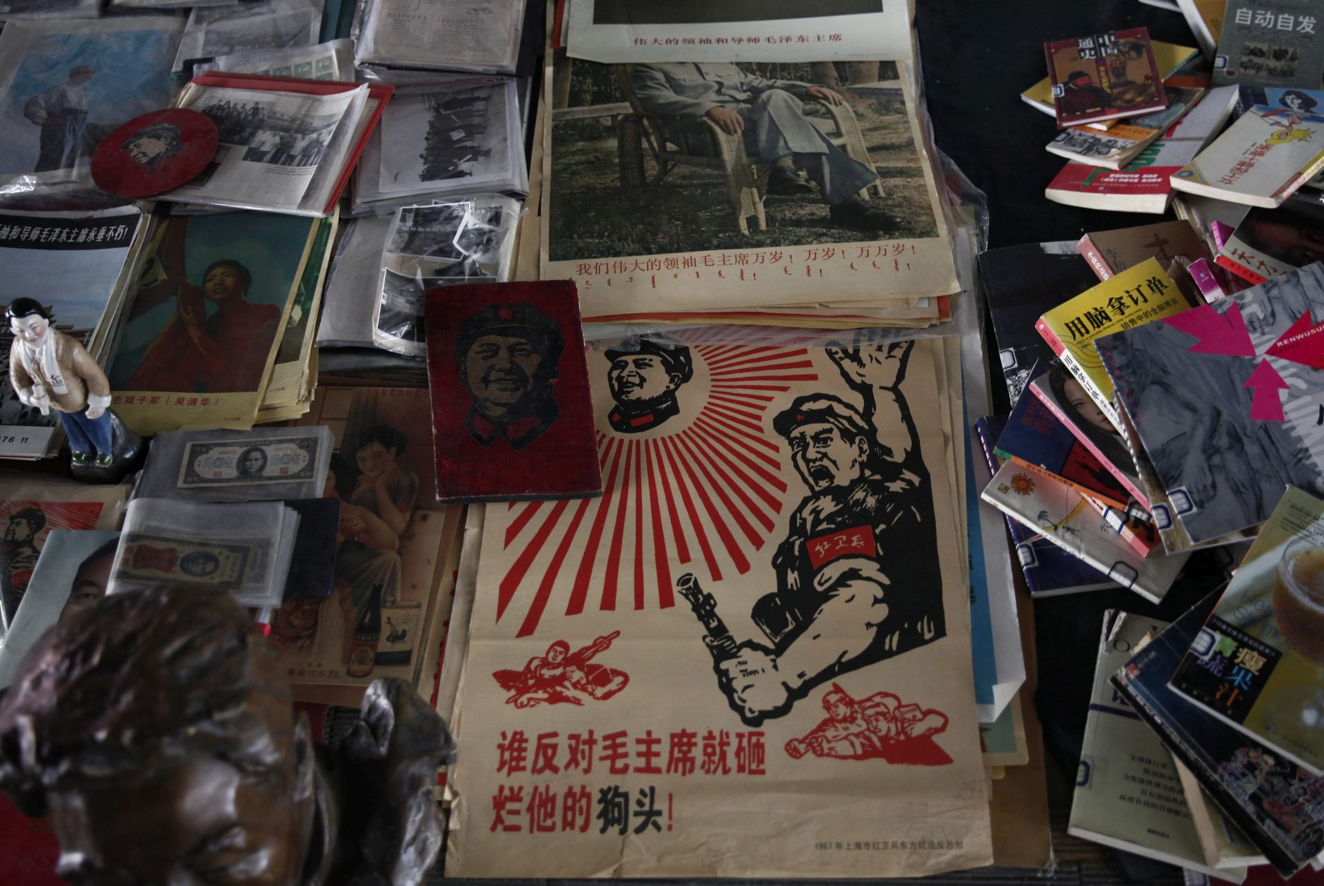 epa05300663 A picture made available 12 May 2016 shows a poster printed with a message that reads 'Anyone who opposes Chairman Mao will be smashed' displayed amidst other memorabilia at the Panjiayuan flea market in Beijing, China, 08 May 2016. Many memorabilia depicting Mao Zedong and items carrying themes reminiscent of China's Cultural Revolution are still sold at Panjiayuan market, a compound of various stalls selling antiques on the southeast side of Beijing. The 50th anniversary of the Cultural Revolution falls on 16 May, although this chapter in China's history is not openly discussed in the mainland due to accounts of persecution that happened during the period against intellectuals deemed enemies of the state.  EPA/ROLEX DELA PENA