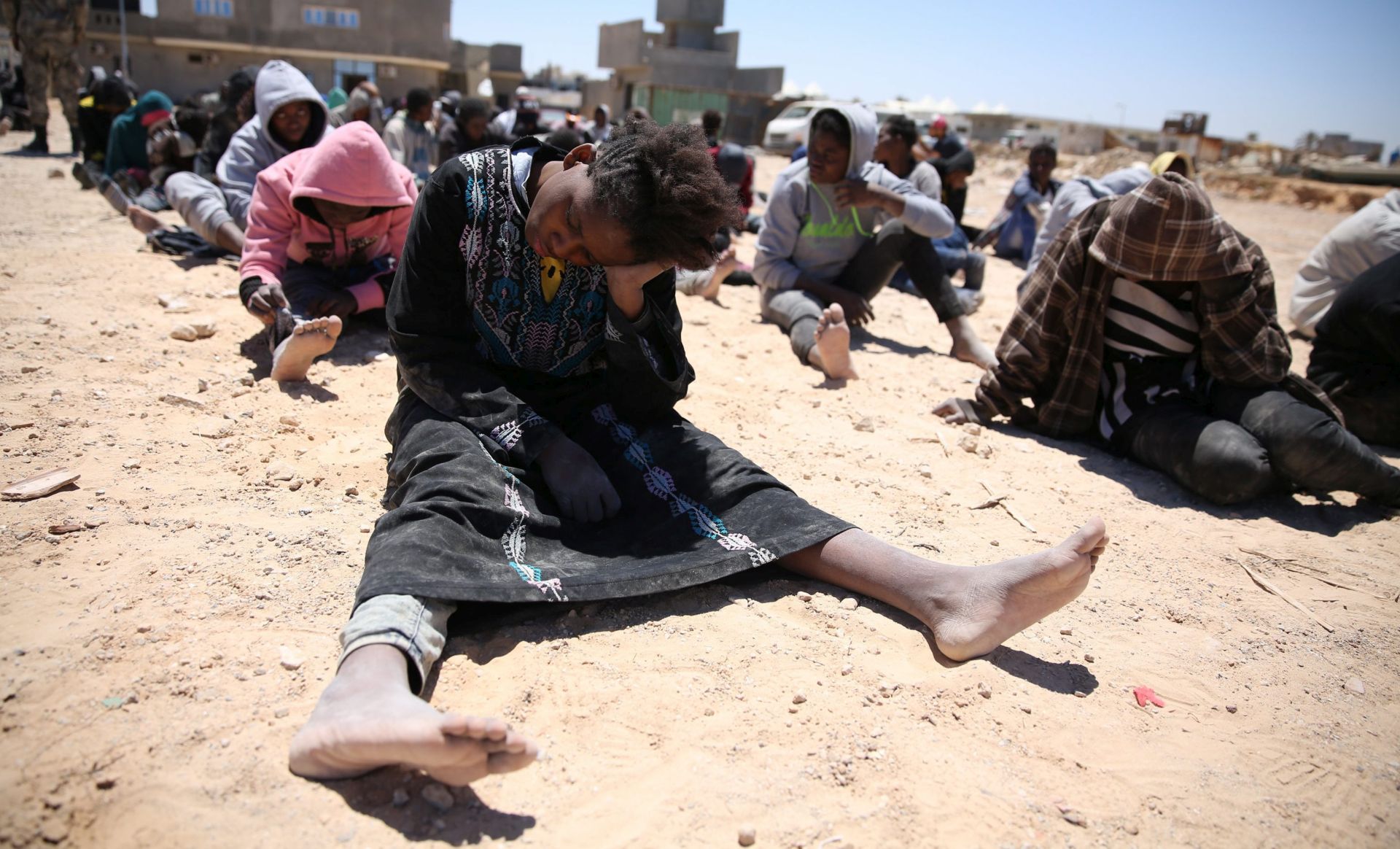 epa05310347 Migrants sit after they were rescued off the shore, in Tripoli, Libya, 16 May 2016. Reports state Libyan costal guards rescued 112 migrants, including women and a child, after a failed attempt to reach Europe.  EPA/STRINGER