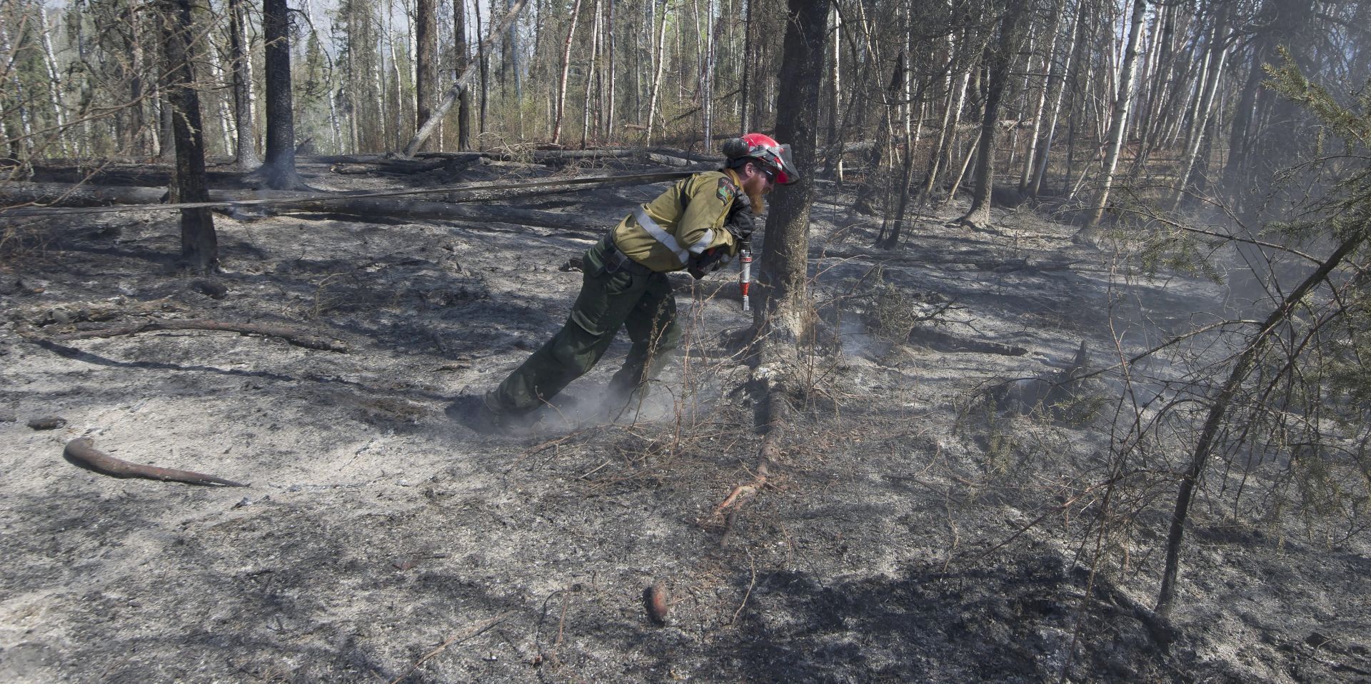 epa05296808 A handout photograph made available by the Government of Alberta, Canada, on 09 May 2016 shows a member of Wildfire Management Alberta's Wild Mountain Unit out of Hinton, draging a hose to douse hotspots in the Parsons Creek area of Fort McMurray, Canada, 06 May 2016. Fire conditions remain extreme, with 12 new starts across Alberta. A total of 40 wildfires are burning. More than 1,200 firefighters, 110 helicopters, 295 pieces of heavy equipment, and 27 air tankers are fighting fires across the province.  EPA/CHRIS SCHWARZ / GOVERNMENT OF ALBERTA / HANDOUT  HANDOUT EDITORIAL USE ONLY/NO SALES  EPA/CHRIS SCHWARZ / GOVERNMENT OF ALBERTA / HANDOUT  HANDOUT EDITORIAL USE ONLY/NO SALES