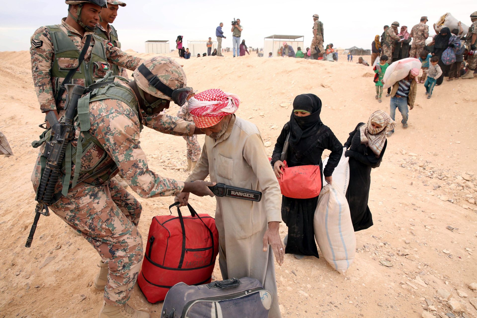 epa05289821 Jordanian border guards inspects Syrian refugees as they arrive to a camp on the Jordanian side at the north east of Jordan border with Syria, Al-Hadalat crossing point near Royashed Town, Jordan, 04 May 2016. according to the Jordanian Commander of the Borders Guards Brigadier Saber Al-Mahayreh, around 5000 Syrians fleeing from the recent attacks on the Syrian city of Aleppo crossed into Jordan in search of safety, most are exhausted and desperately in need of help and medical treatment.  EPA/JAMAL NASRALLAH