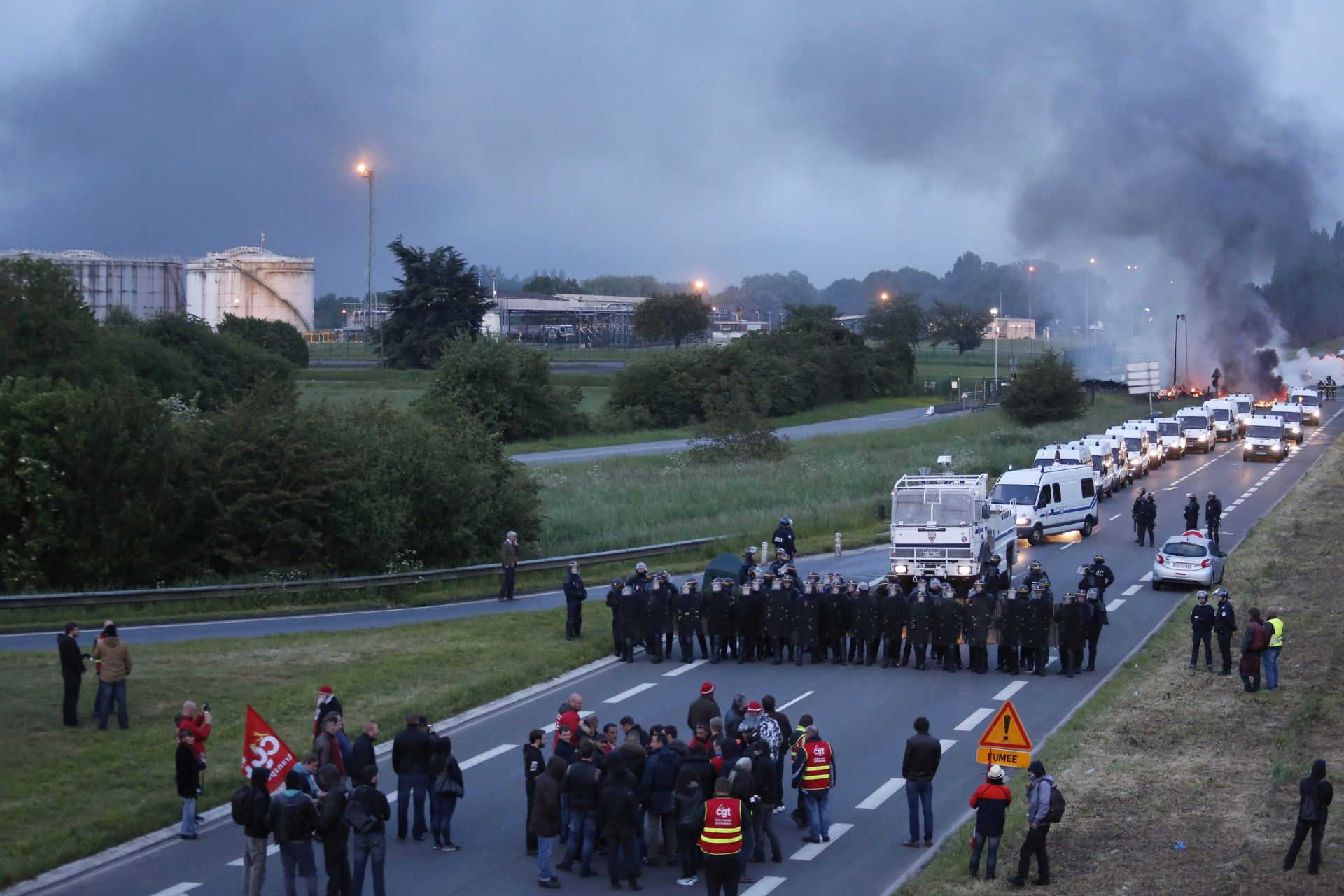 epa05327822 French police dislodge protesters blocking a fuel depot after trade unionists erected a burning barricade to block the entrance of a refinery in Douchy-les-Mines, northern France, early 25 May 2016. A strike hit oil refineries, fuel depots and petrol stations across France.  EPA/THIBAULT VANDERMERSCH