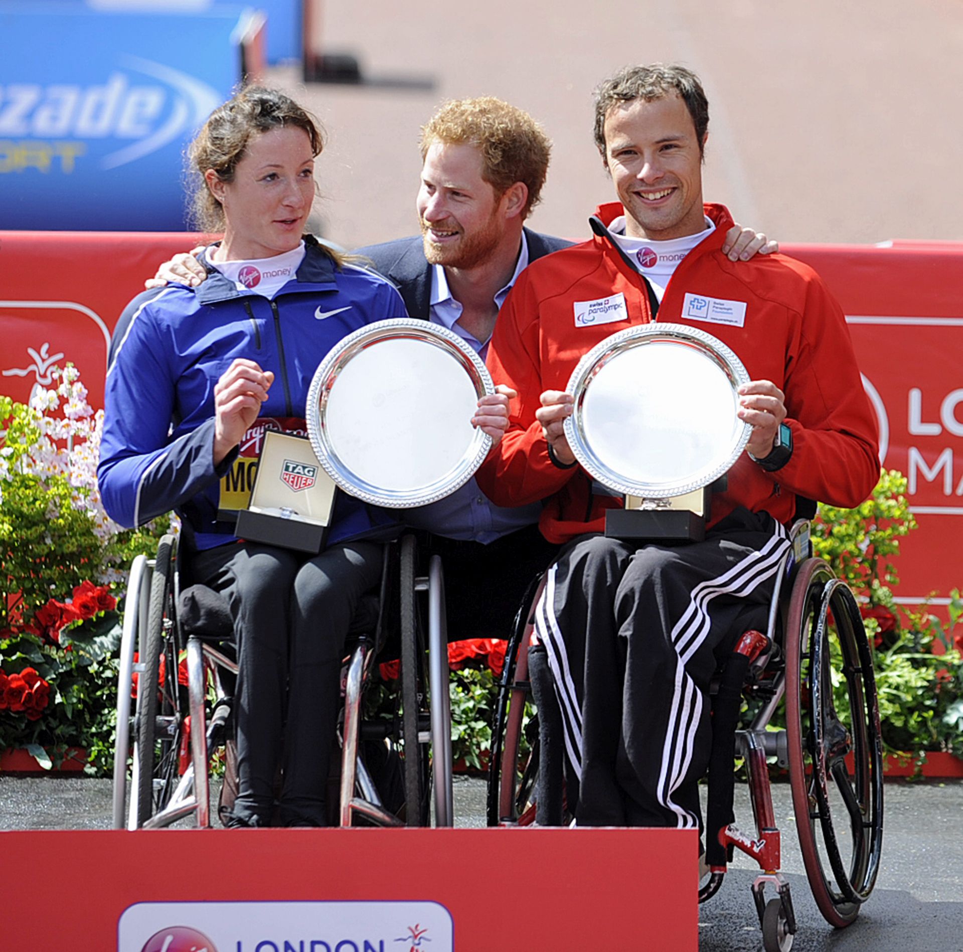 epa05275234 Men's winner Marcel Hug (R) of  Switzerland and women's winner Tatyana McFadden of the USA (L) pose together with Britain's Prince Harry (C) after being presented with their trophies for the wheelchair race at the London Marathon, Britain, 24 April 2016.  EPA/GERRY PENNY
