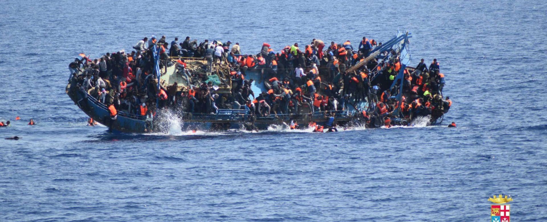 epa05328919 A handout picture released by the Italian Navy shows people jumping out of a boat right before it overturns in Canal of Sicily off the Libyan coast, 25 May 2016. The Italian navy says it has recovered five bodies from the overturned migrant ship. Over 550 migrants on board were rescued safely.  EPA/ITALIAN NAVY / HANDOUT  HANDOUT EDITORIAL USE ONLY/NO SALES