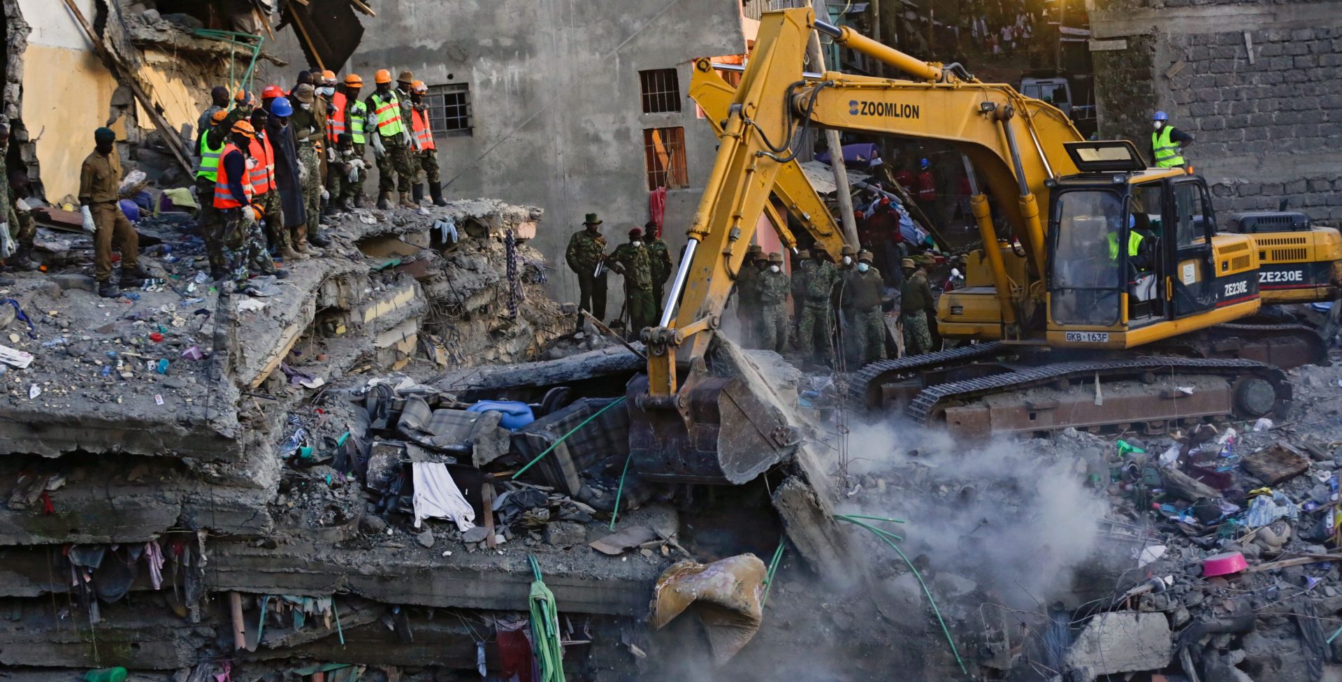 epa05288690 Local residents look at a collapsed building across the river as rescue operations continue in the Huruma estate of the Mathare slum, Nairobi, Kenya, 03 May 2016. A baby aged seven months was rescued alive from the rubble of a collapsed six-storey building Huruma, Nairobi, after 4 days, the hospital confirmed. At least 22 people were killed when the house collapsed on 29 April during heavy rain.  EPA/DANIEL IRUNGU
