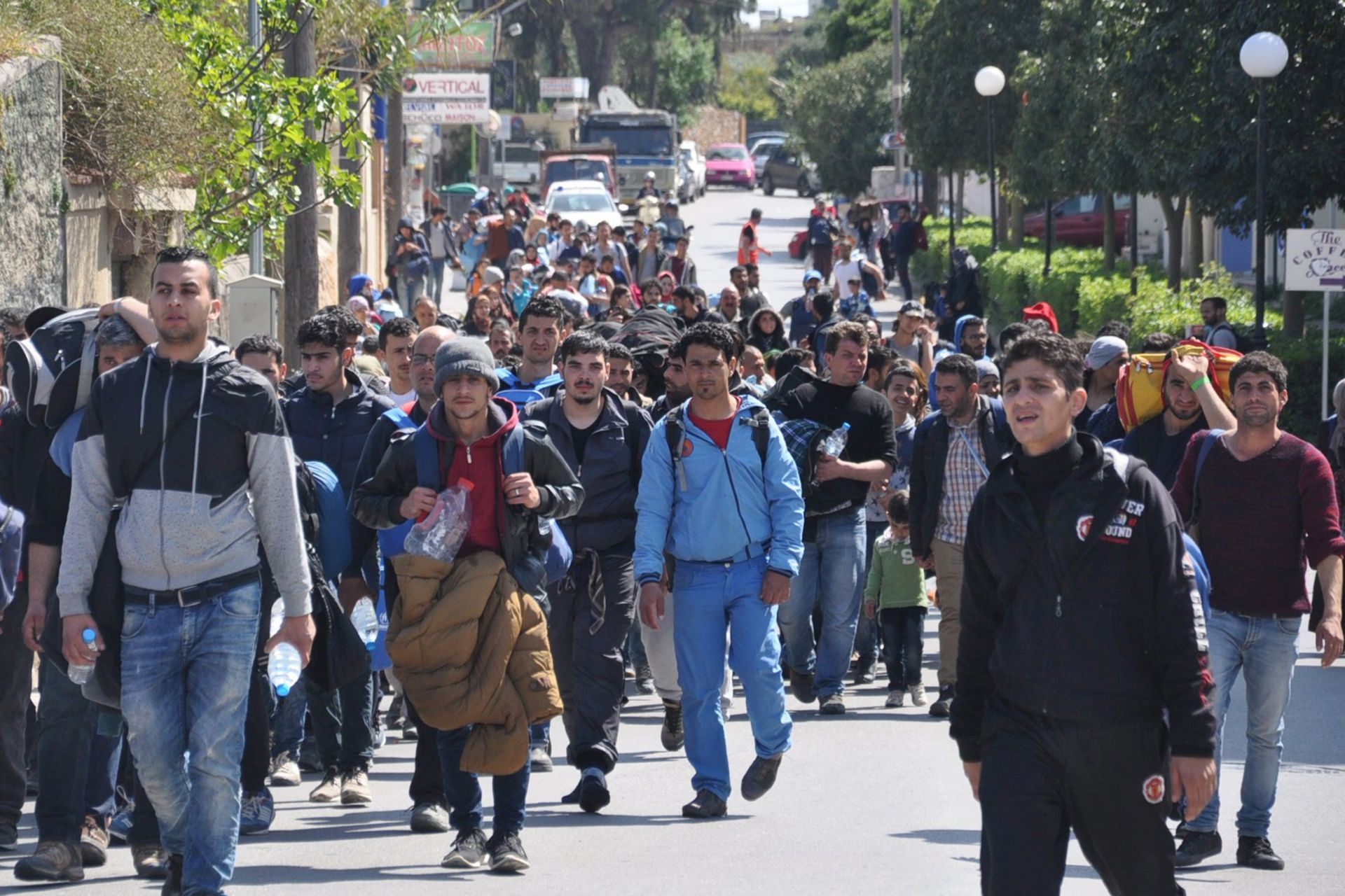 epa05239185 Migrants walk in a street of Chios city, on Chios island, Greece, 01 April 2016. A group of more than 500 refugees and migrants, most of them families with children, reportedly broke through a fence and headed out of the Chios hotspot where they were being held.  EPA/ORESTIS PANAGIOTOU