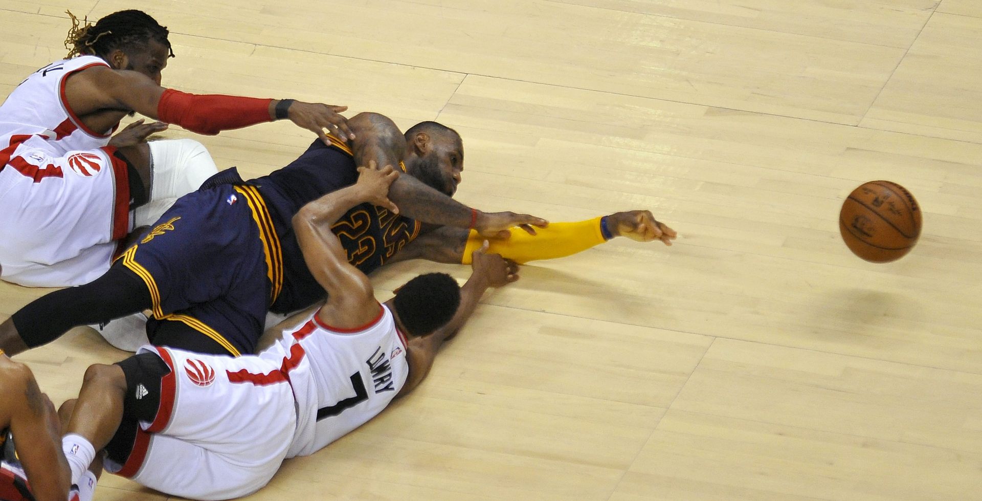 epa05325886 Cleveland Cavaliers forward LeBron James (C) tries to pass the ball after colliding with Toronto Raptors forward DeMarre Carroll (L) and guard Kyle Lowry during the fourth quarter of game four in the NBA Eastern Conference basketball finals at the Air Canada Center in Toronto, Canada, 23 May 2016. The Raptors defeated the Cavaliers 105-99.  EPA/WARREN TODA CORBIS OUT