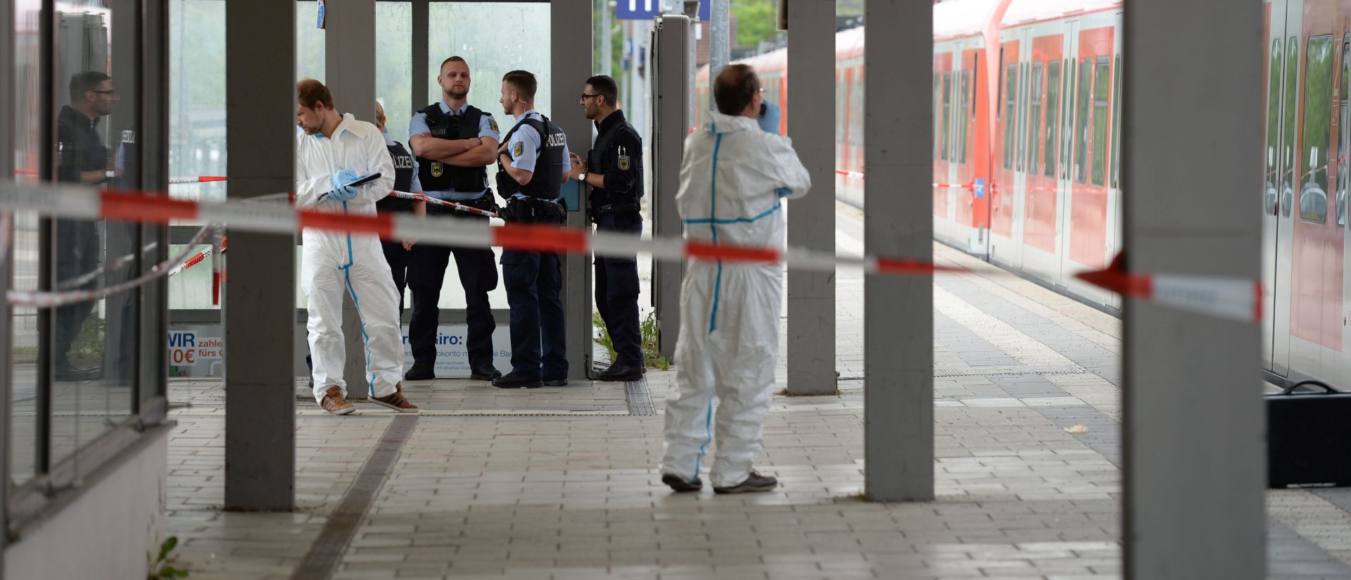 epa05297355 German forensic investigators uniformed police officers next to a local train at the railway station in Grafing near Munich, Germany, 10 May 2016. At least four people were injured during a knife attack at the railway station in the morning of 10 May. One of the victims sustained serious injuries.  EPA/ANDREAS GEBERT