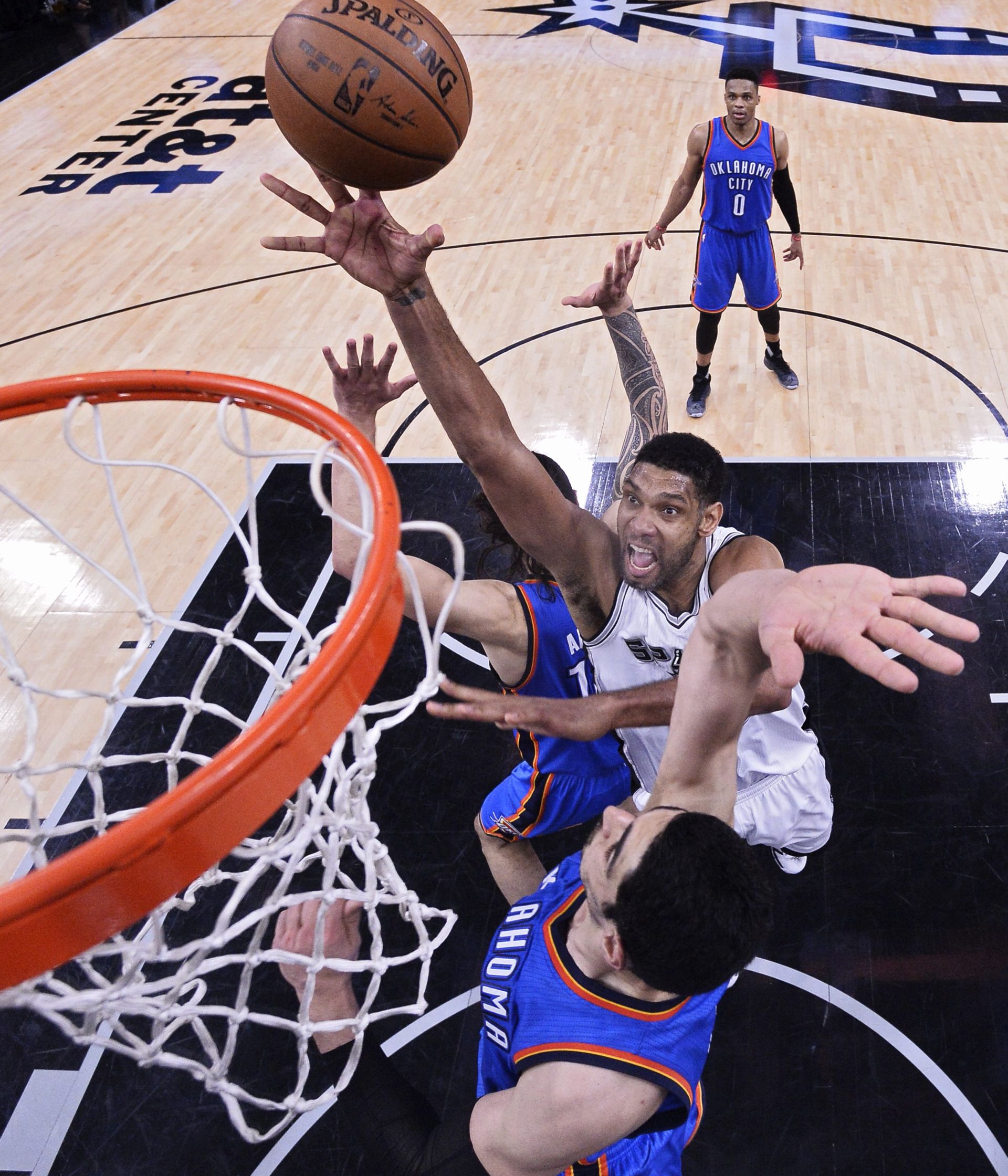 epa05298638 San Antonio Spurs player Tim Duncan (C) goes to the basket against the Oklahoma City Thunder during the second half of the NBA Western Conference semifinal basketball game five between the Oklahoma City Thunder and the San Antonio Spurs at the AT&T Center in San Antonio, Texas, USA, 10 May 2016.  EPA/LARRY W. SMITH CORBIS OUT