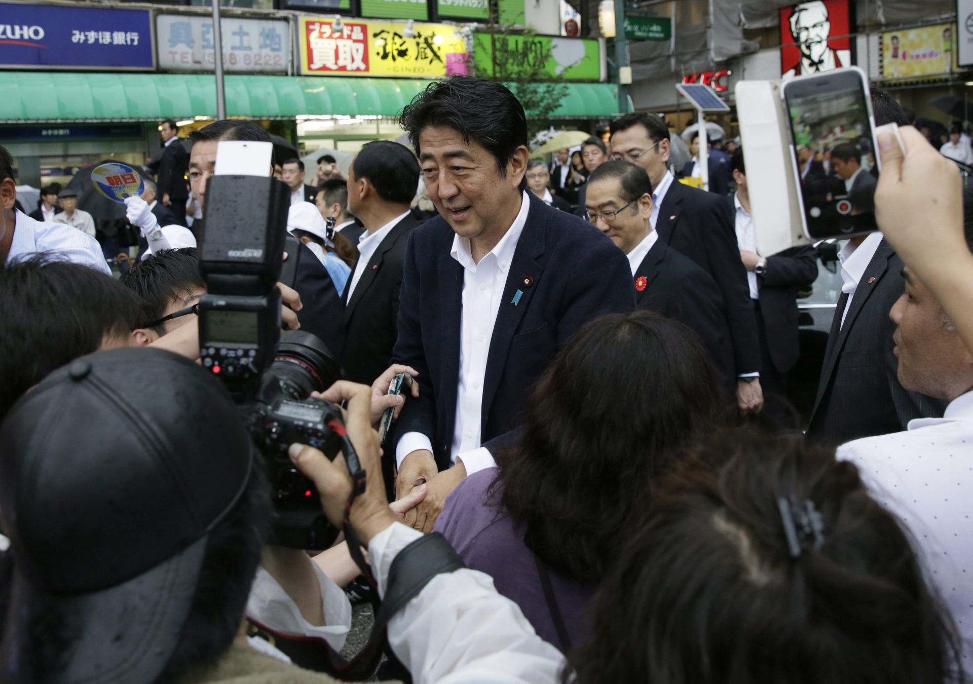 epa05416377 Japanese Prime Minister Shinzo Abe shakes hands with people after speaking to voters to support his ruling Liberal Democratic Party's candidate during a final campaign for the Upper House election in Tokyo, Japan, 09 July 2016. The election will be held on 10 July 2016. It is the first national election after Japan lowered the voter's age from 20-year-old to 18.  EPA/KIMIMASA MAYAMA