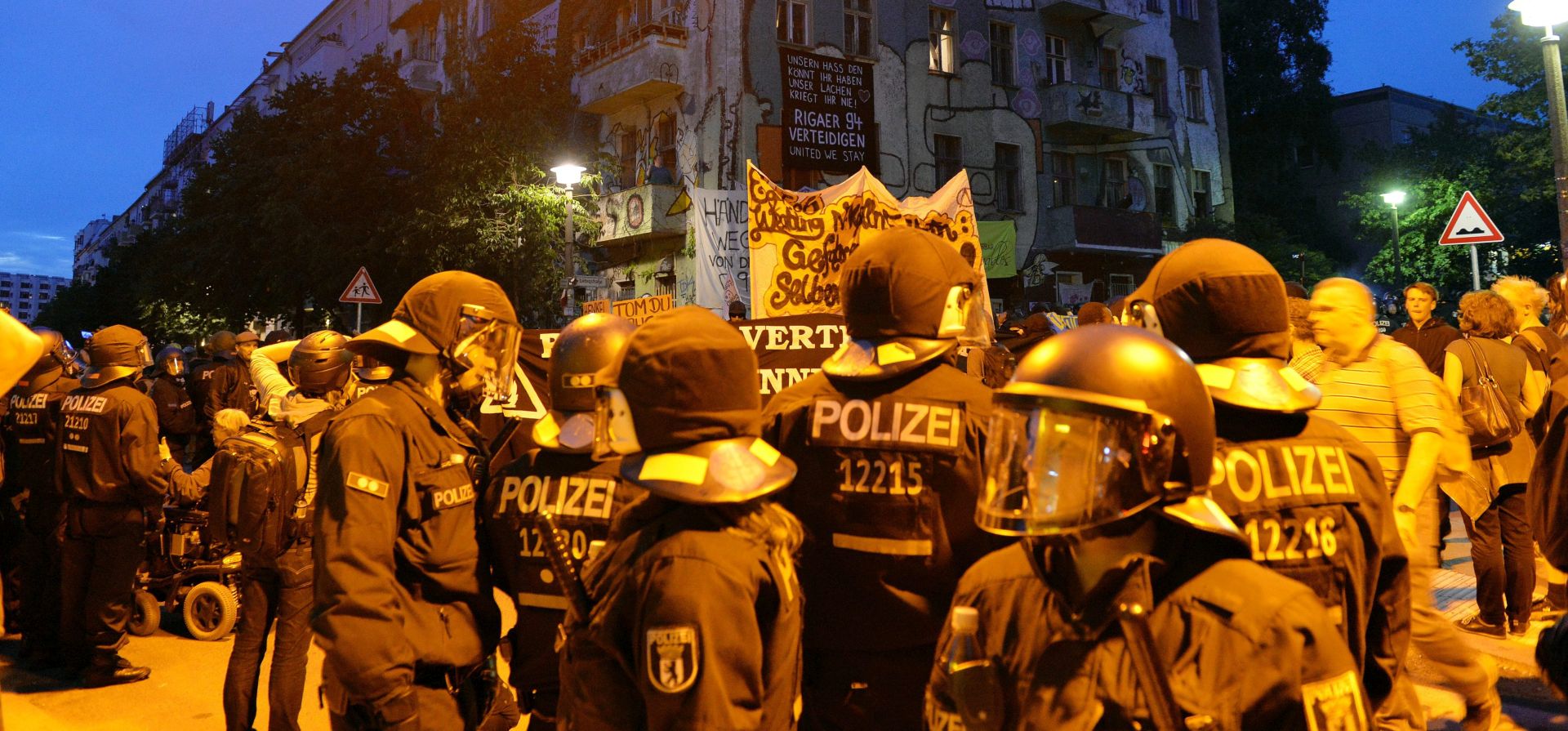 epa05417794 German riot police forces gather in front of a housing complex in Berlin's Rigaer Street, where a demonstration of left-wing supporters of a group of squatters turned tense, in Berlin, Germany 09 July 2016 evening. Police was called to enforce demands of the building's owner to evacuate the building within plans for a reshaping of the area. Recent police actions to evacuate the building had caused partially violent demonstration of leftist groups, including the burning of cars in the neighborhood.  EPA/MAURIZIO GAMBARINI