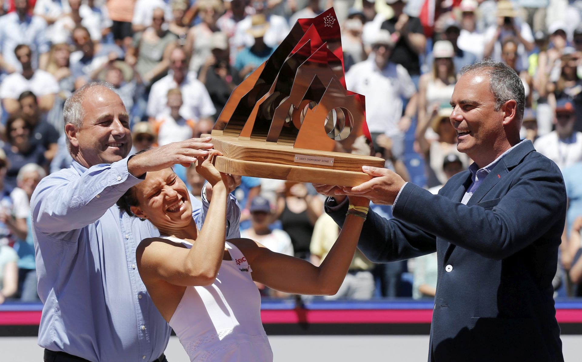 epa05429038 Viktorija Golubic of Switzerland lifts up the trophy with Albert Bach (L), mayor of Saanen-Gstaad, and tournament director Jeff Collet (R), after winning the final match against Kiki Bertens of the Netherlands at the WTA Ladies Championship tennis tournament in Gstaad, Switzerland, 17 July 2016.  EPA/PETER KLAUNZER