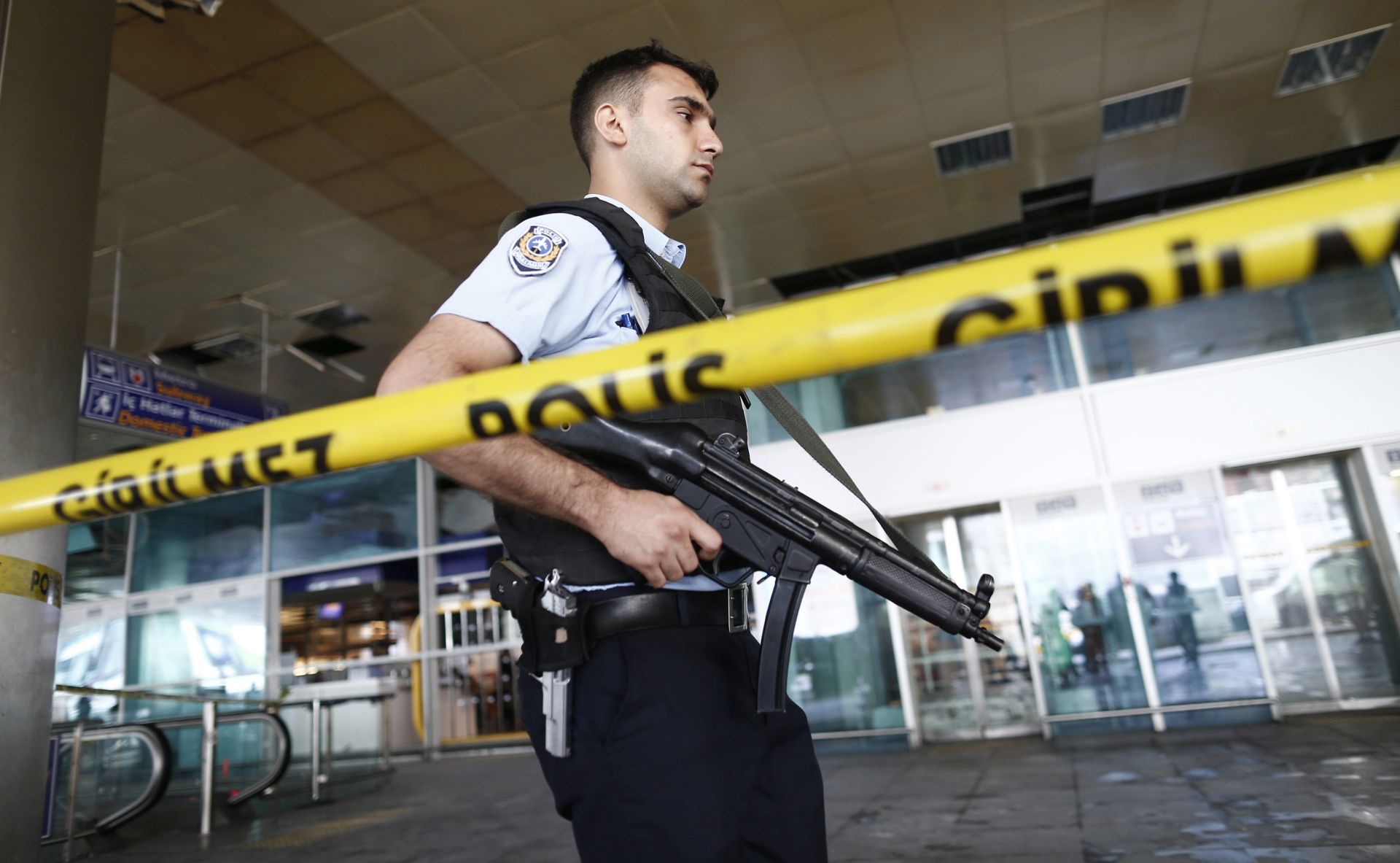 epa05397160 An armed Turkish policeman patrols behind a police line after multiple suicide bomb attacks at Ataturk international airport in Istanbul, Turkey, 29 June 2016. At least 36 people were killed and more than 140 others were wounded in three separate gun and bomb attack outside and inside the terminal of Istanbul's Ataturk international airport on 28 June, media reported quoting officials. The attacks have been linked to either the so-called Islamic State (IS or ISIS) militant group or Kurdish separatists, media added.  EPA/SEDAT SUNA