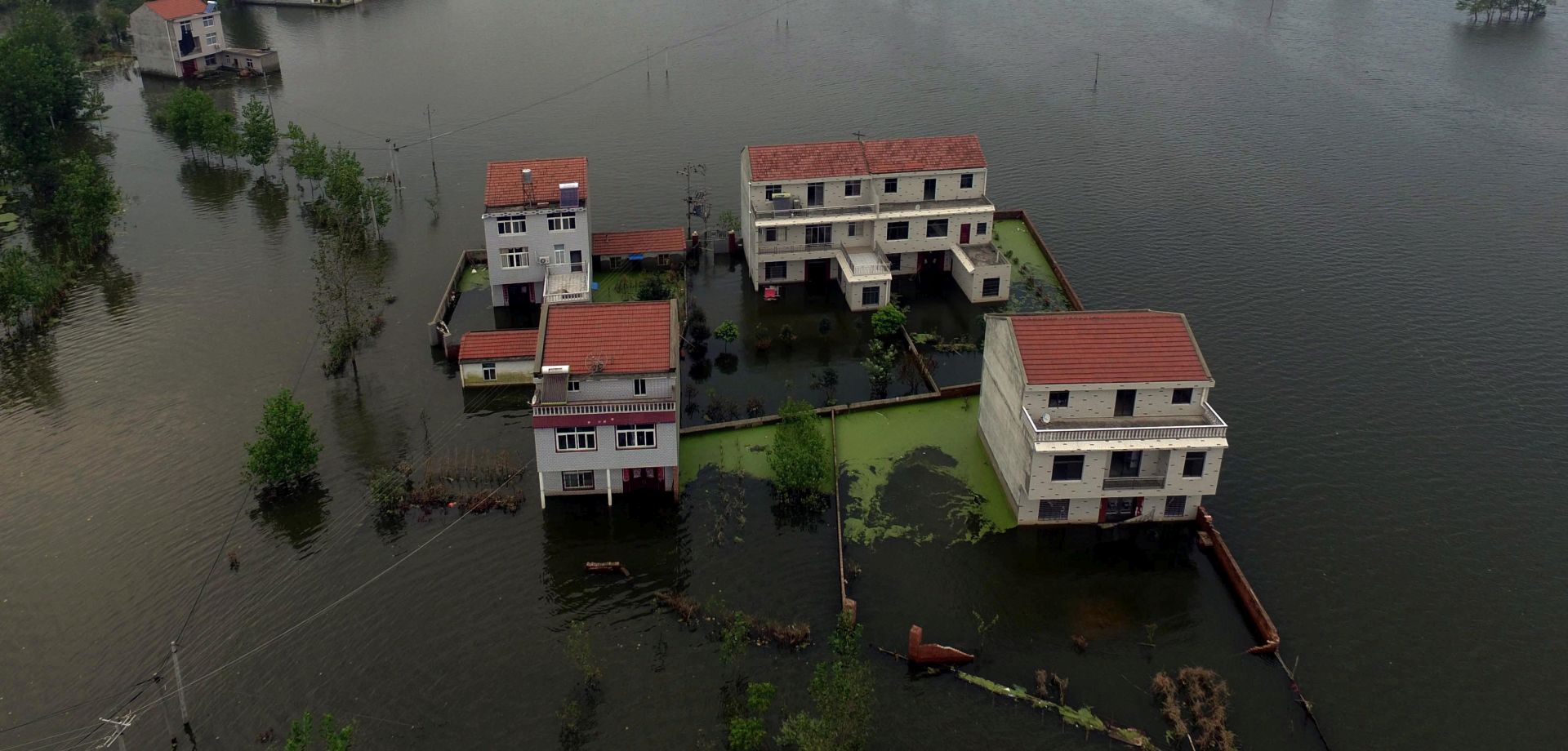 epa05438051 A picture made available on 23 July 2016 of an aerial view of waters flooding Xinhua Village of Xinchang county in Wuhan city, Hubei Province of central China on 18 July 2016. Floods caused by heavy rainfall in north and central have killed more than 70 people, leaving many missing and hundreds of thousands homeless according to local reports.  EPA/MARK CHINA OUT