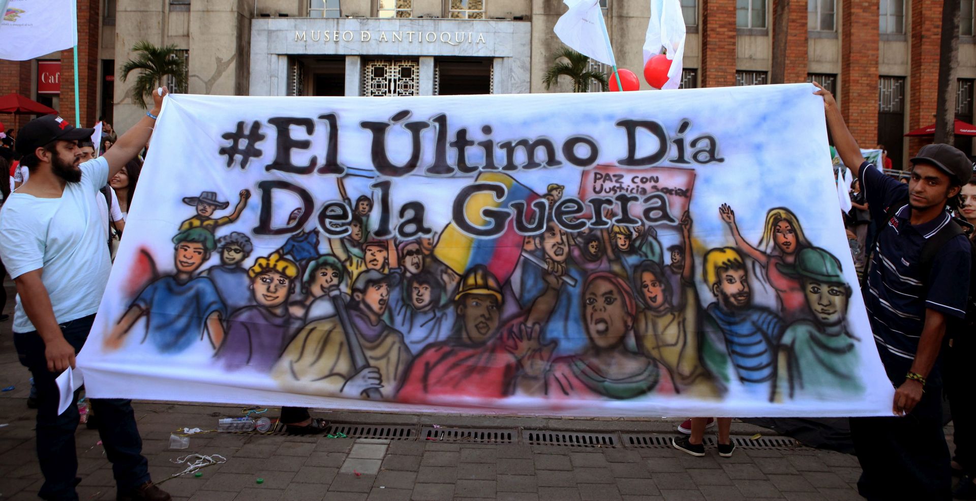epa05386877 People hold a banner during an event to celebrate the signing of the cease-fire agreement between the Colombian government and the Revolutionary Armed Forces of Colombia (FARC) guerrilla group, in Medellin, Colombia, 23 June 2016. An agreement aimed at ending more than five decades of conflict between the Colombian government and the FARC guerrilla group was signed here on 23 June at a ceremony presided over by Cuban head of state Raul Castro.  The banner reads 'The last day of war'.  EPA/LUIS EDUARDO NORIEGA