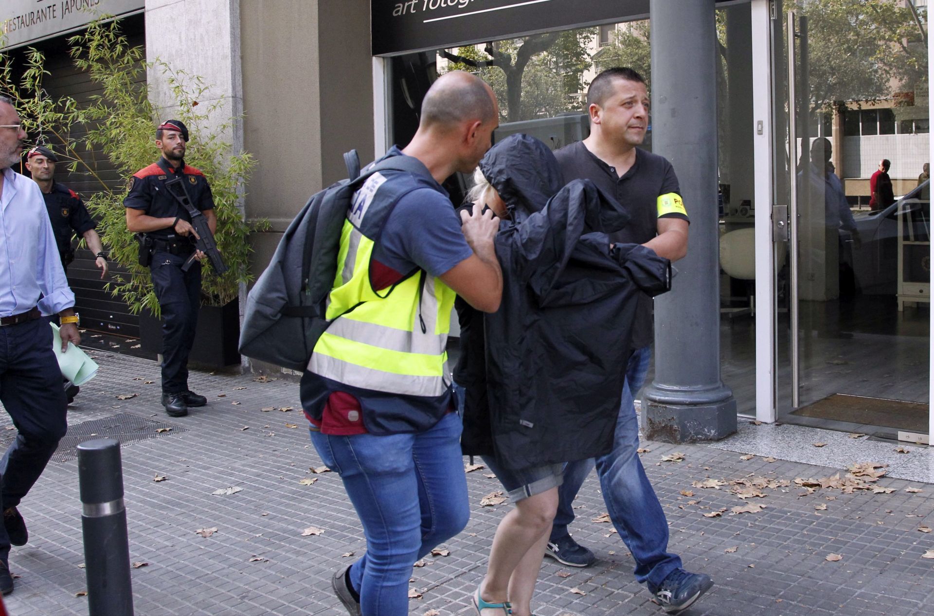 epa05421482 A woman (C) is arrested as part of a police operation by Spanish police and Catalonian regional Mossos d'Esquadra's officers, outside Japanese restaurant, Yubari, in Barcelona, Catalonia, northeastern Spain, 12 July 2016. The authorities investigated a gang which allegedly laundered 10 million euro from organized crime through real estate and the Japanese luxury restaurant, Yubari. It is expected that eleven people have been arrested in connection with the gang, mainly made up of Ukrainian and Russian nationals.  EPA/MARTA PEREZ